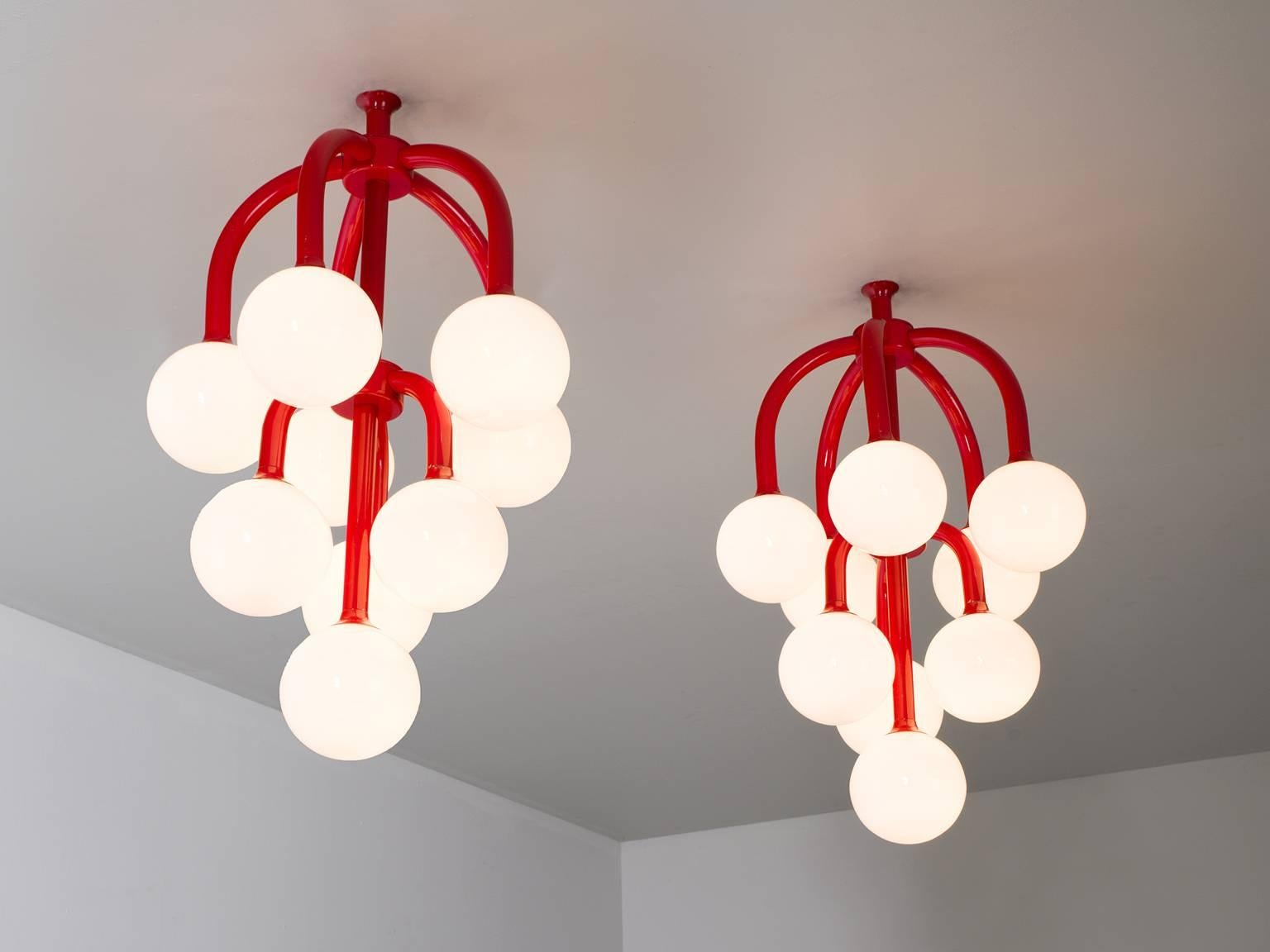 Set of two chandeliers, in metal and opaline glass, Scandinavia, 1970s.

Elegant pair of sputnik-like chandeliers. The red coated metal fixture consist of several arches, all with an opal sphere at the end. The light is divided over three levels.