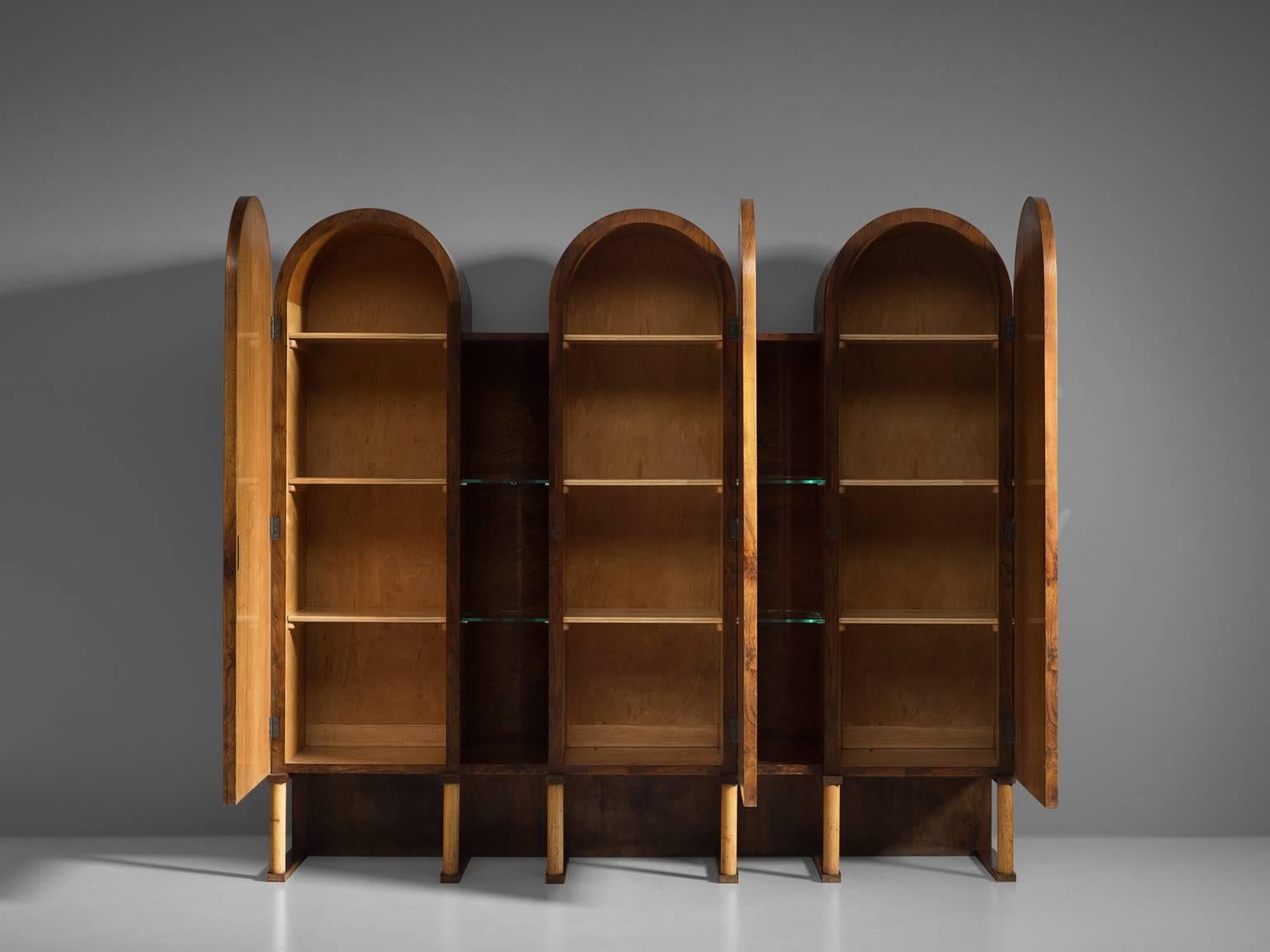 Cabinet, walnut burl, wood, glass, Italy, 1960s.

This sensuous cabinet is executed in walnut burl. The cabinet features three arches with three burl doors, and four shelves. In between the arches are open gaps with featuring two glass shelves.