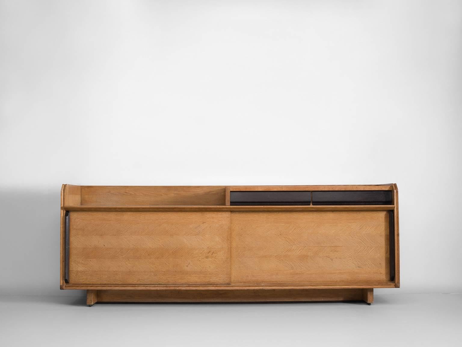 Credenza, in oak, metal and ceramic, by Robert Guillerme et Jacques Chambron for Votre Maison, France, 1960s.

This cabinet is designed by the French designer duo Guillerme and Chambron. The sideboard is characterised by the oakwood inlay patterns