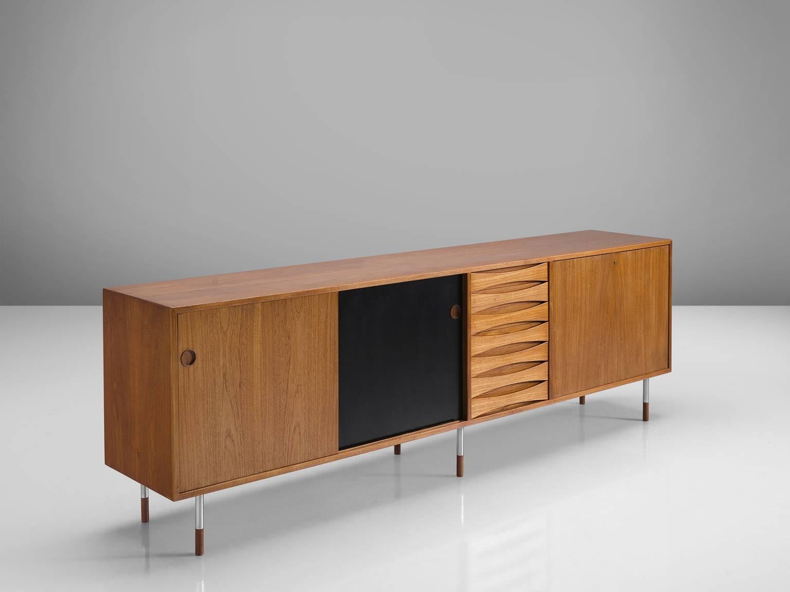 Arne Vodder for P. Olsen Sibast Møbler, credenza model 29A, in teak and metal, by Denmark, 1959.

This iconic sideboard in teak is designed by the Danish designer Arne Vodder. The typical refined Vodder details can be found on this sideboard such as