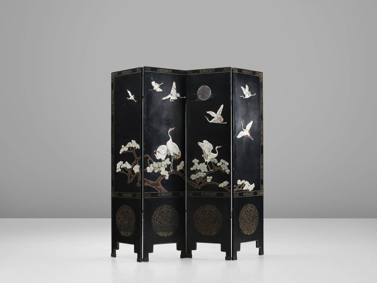 Room divider, with Japanese nature depiction, Europe, 1960s.

This splendid screen features a Stark black base with white and golden figures. The iconic cranes and Japanese cherry blossom are featured along side a moon. The screen has four folding