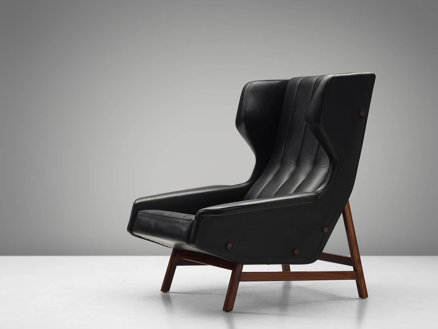 Gianfranco Frattini, lounge chair model 877, black aniline leather and rosewood, made by Cassina, Italy, circa 1959.

Sturdy and voluminous lounge chair in black leather, reupholstered in our in-house workshop. This wingback chair shows nice details