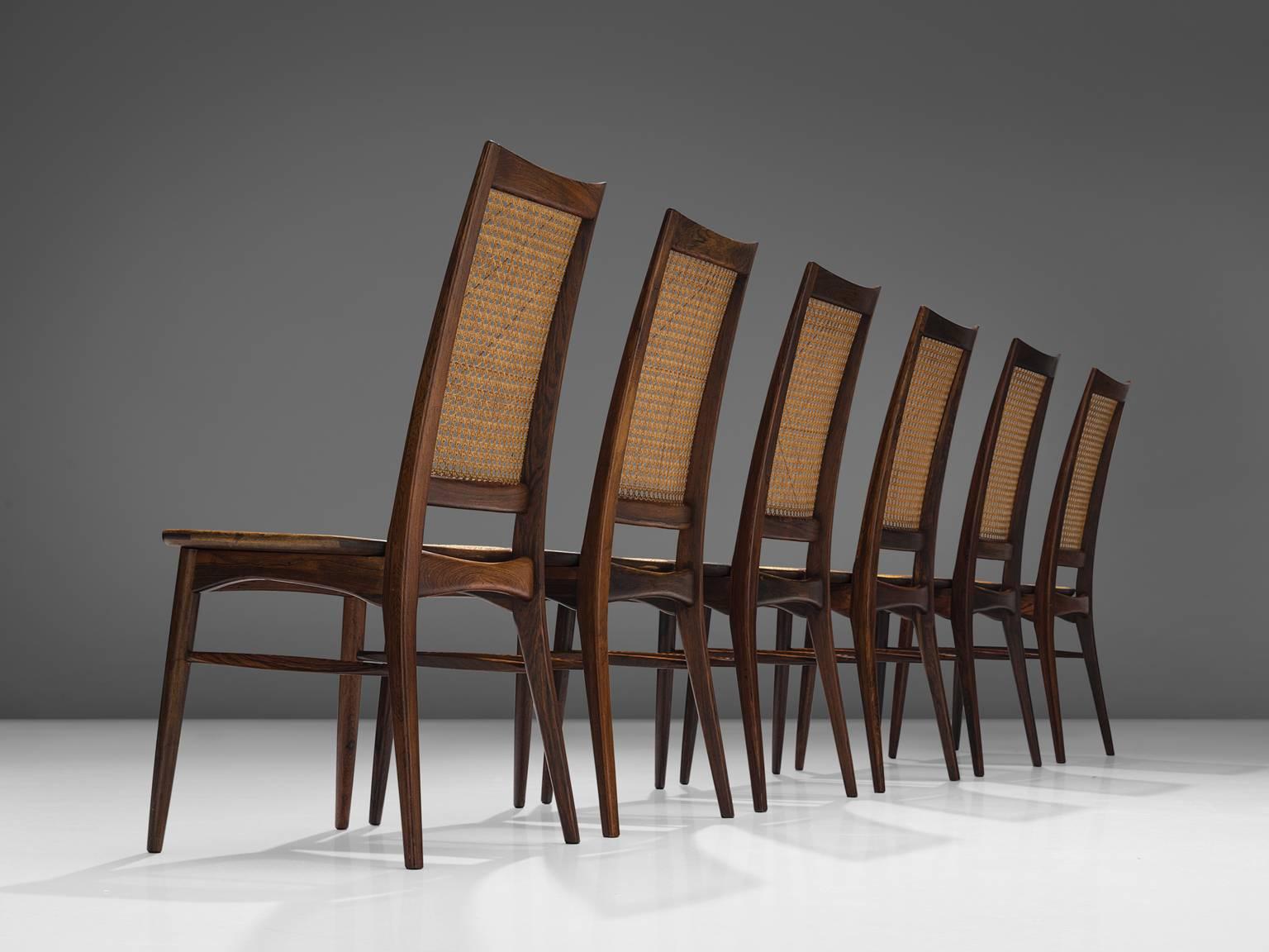 Niels Kofoed, set of six dining chairs, rosewood and wicker, Denmark, 1960s. 

Set of six refined high back dining chairs in rosewood and cane. These high back chairs have an elegant and recognizable Scandinavian design. The elegant high back is