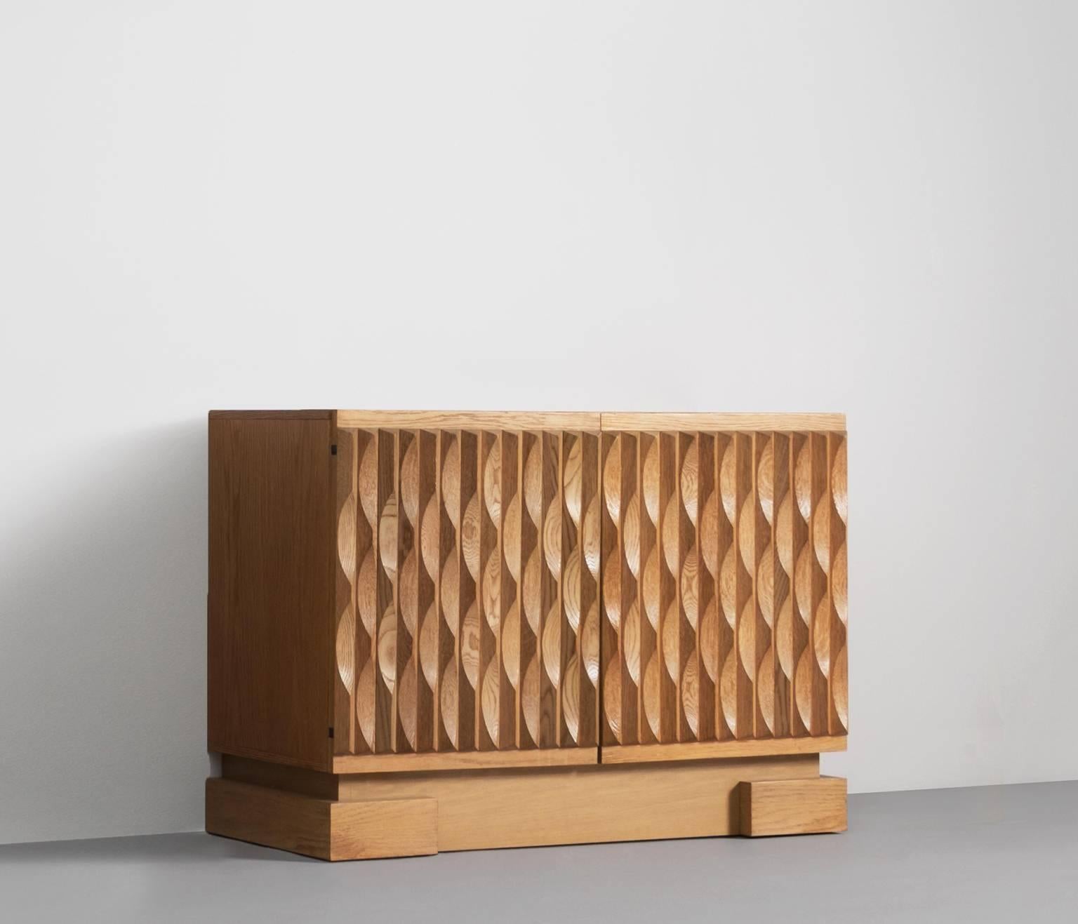 Wonderful Brutalist sideboard with very nice designed solid oak door panels, Belgium, 1970s.

In the 1970s a few Belgium designers started experimenting this kind of designs. Most of them worked with veneered panels and graphic designs.

This