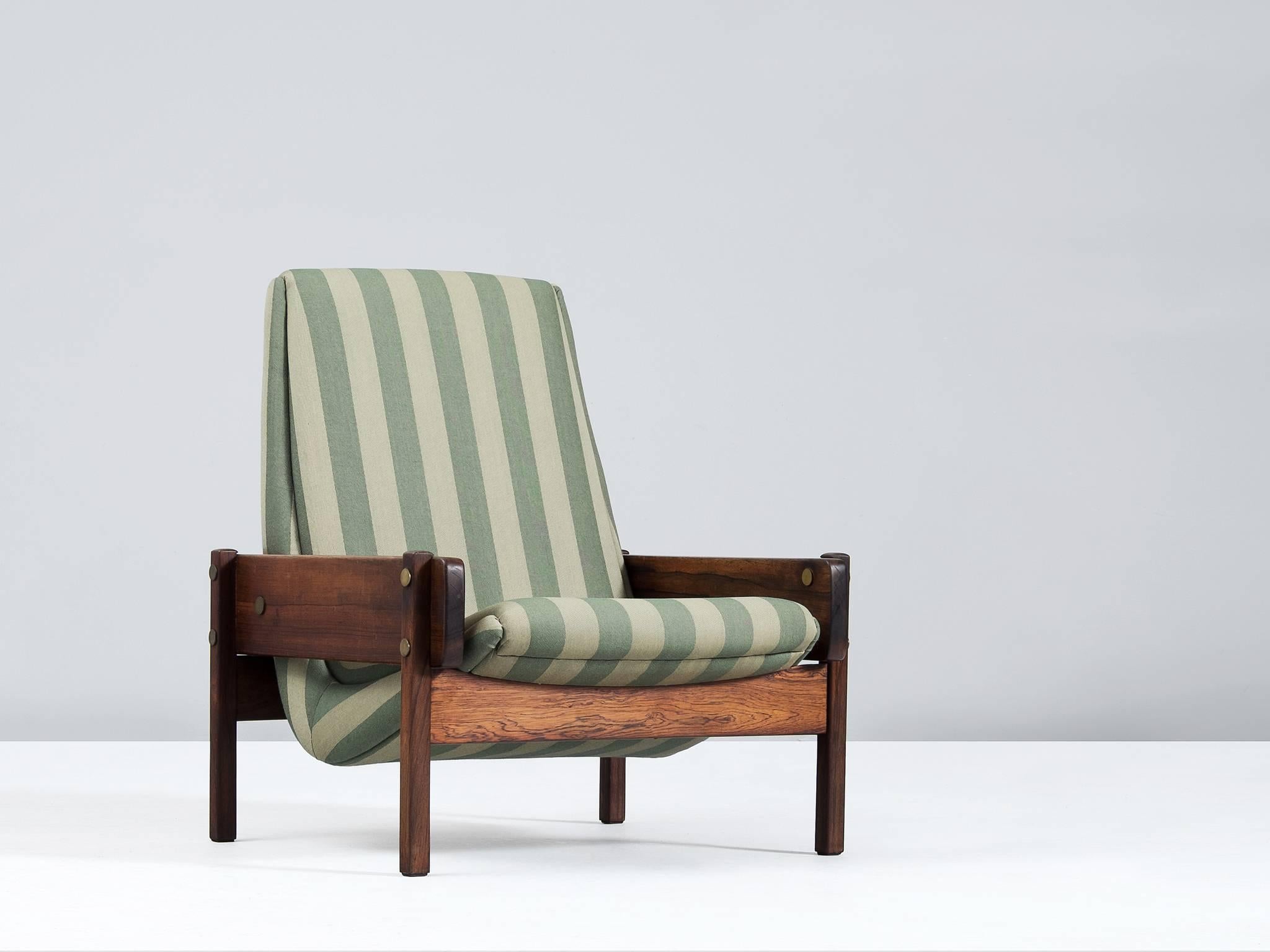 Lounge chair 'Vronka,' in rosewood, brass and fabric, by Sergio Rodriguez for OCA Brazil, 1962. 

Wonderful example of the 'Vronka' chair by Sergio Rodrigues. The solid rosewood frame forms an excellent combination with the brass connectors. The