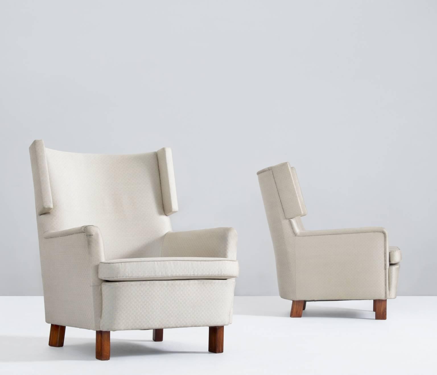Very nice designed Swedish pair of Danish mid-century wingback chairs in off white upholstery. Very Interesting shapes with nice wingback detail.

Currently upholstered in original white detailed fabric we advise re-upholstery in order to fully
