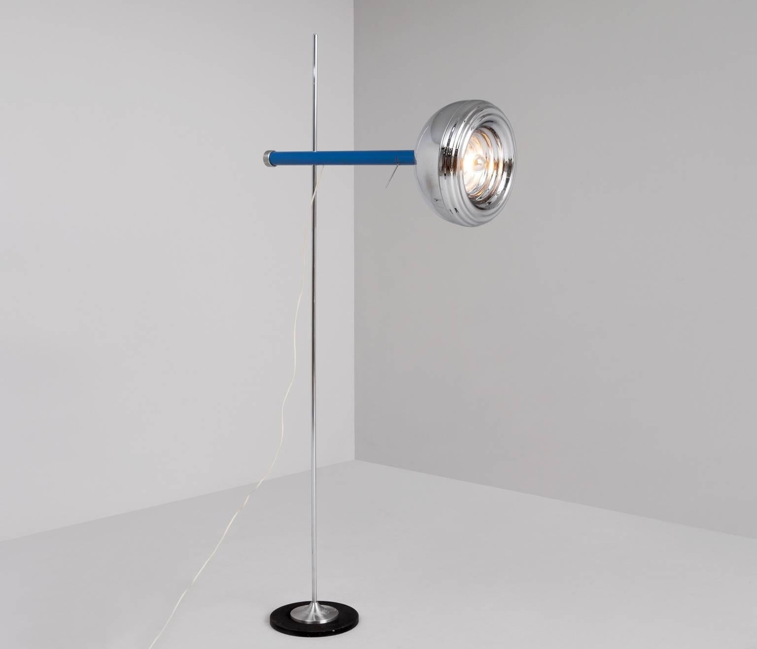Adjustable floor lamp, in chromed metal, Italy, 1980s.

The well made lamp has a plain base with a chrome vertical stem and an interesting chrome shade. The shade is attached to the vertical base with a horizontal clear blue tube. The corded nut on