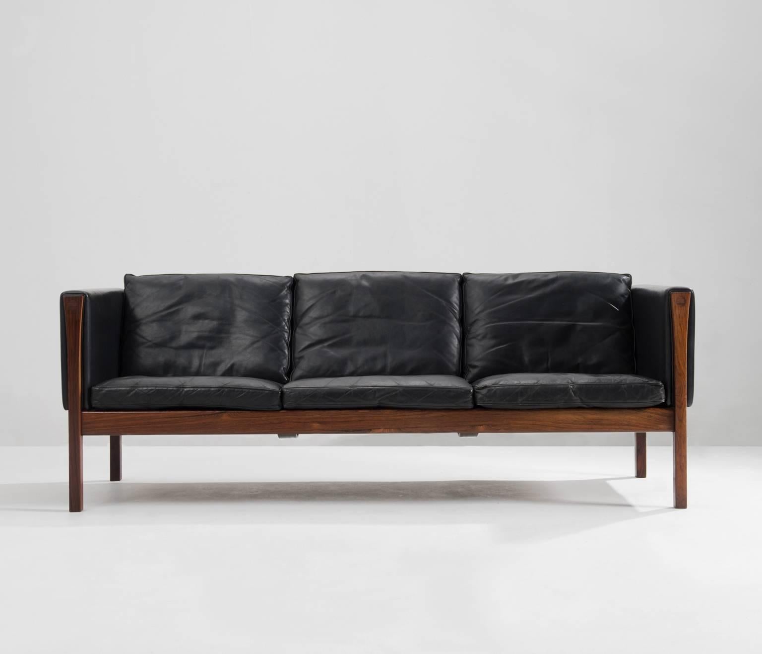 Fatastic Hans J. Wegner 3 seater sofa AP62 in black leather and rosewood, Denmark 
 
Excellent designed sofa by Hans Wegner, originally produced by AP Stolen. 
The straight lines of this iconic design shows an amazing elegance. The solid rosewood