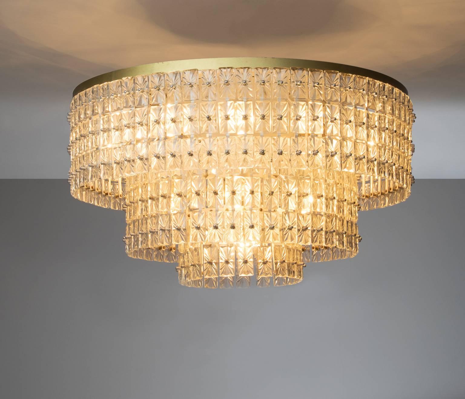 Extraordinary large chandelier in glass and brass, Austria, 1950s.

This wonderful ceiling lamp has a basic shape, built from a large amount of well detailed glass elements. They are mounted to a sincere construction, and beautifully enlightened by