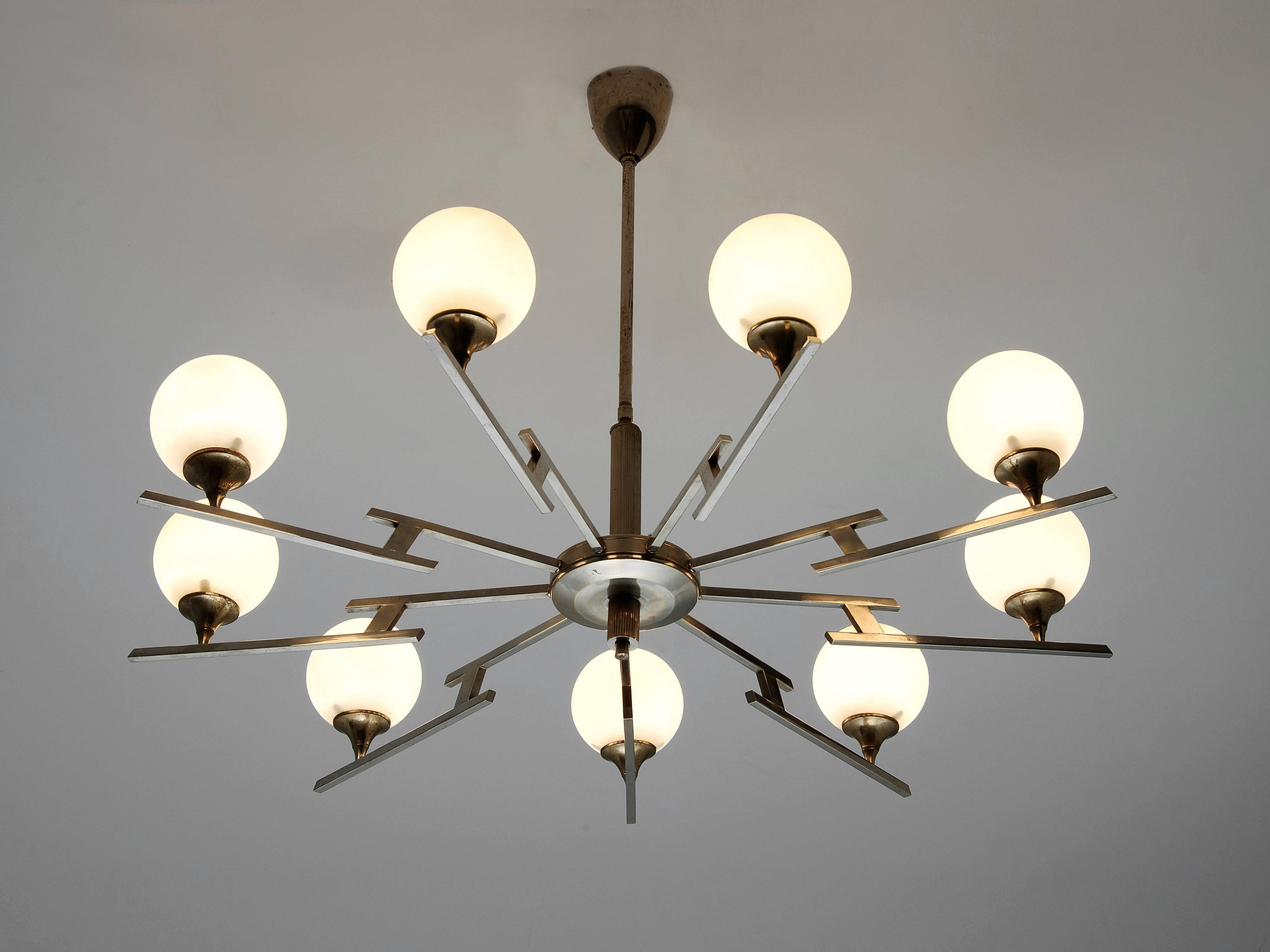 Stunning large chandelier in chrome and opaline glass, Italy, 1950s.

This amazing chandelier has a very strong appearance and spreads a wonderful light. The nine opaline glass bulbs were mounted to a smoothly shaped element in brass, that is held