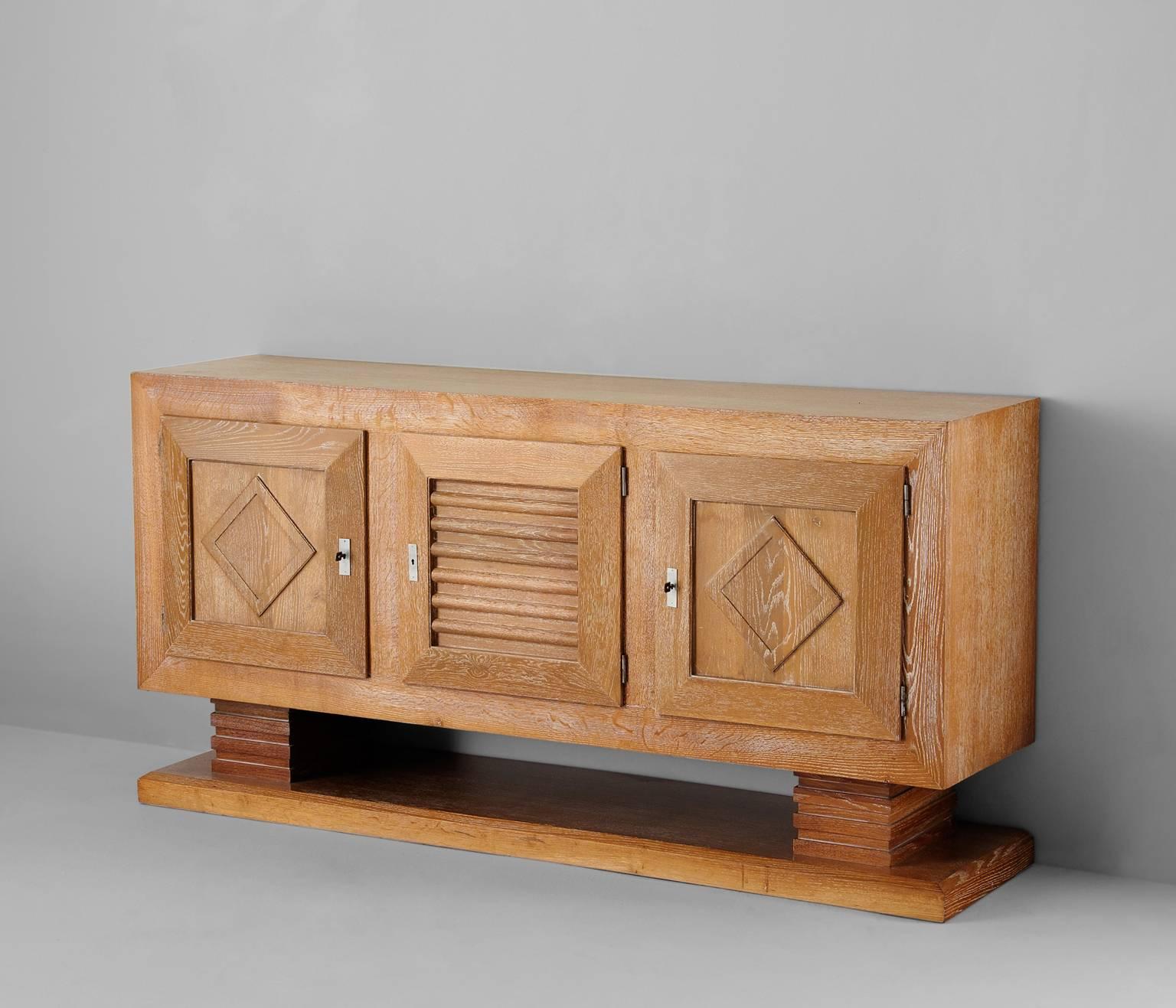 Highly exceptional Art Deco credenza by Charles Dudouyt, France 1940s. 

This buffet is very well crafted in cerused oak, showing an overall white wash look. The storage contains two large compartments with interesting graphically patterned door