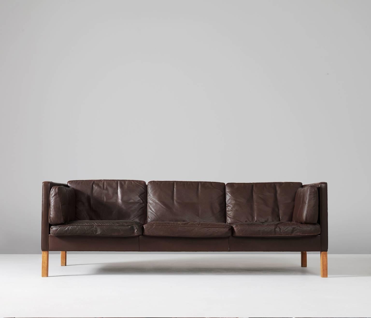 Sofa model 2443, brown leather and oak, by Børge Mogensen for Fredericia Stolefabrik, Denmark, 1960s. 

This design comes from the 1960s and has wonderful shapes and comfort. The three-seater sofa comes with loose cushions in de seating, back and