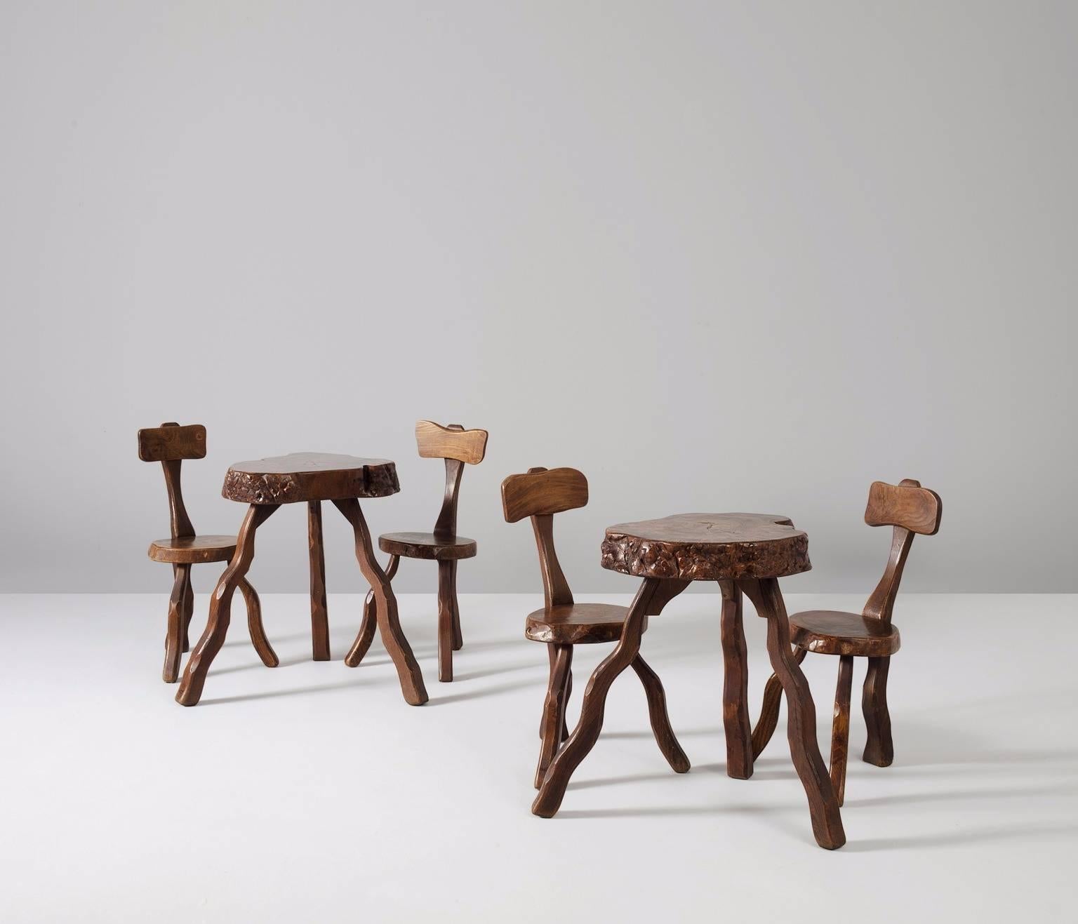 Two sets of root chairs and side tables, solid elmwood, France 1970s.  

Slab side tables in elm, solid and dark brown stained. These three-legged tables have a capricious appearance, due to the natural form and structure of the wood.  

Simplistic