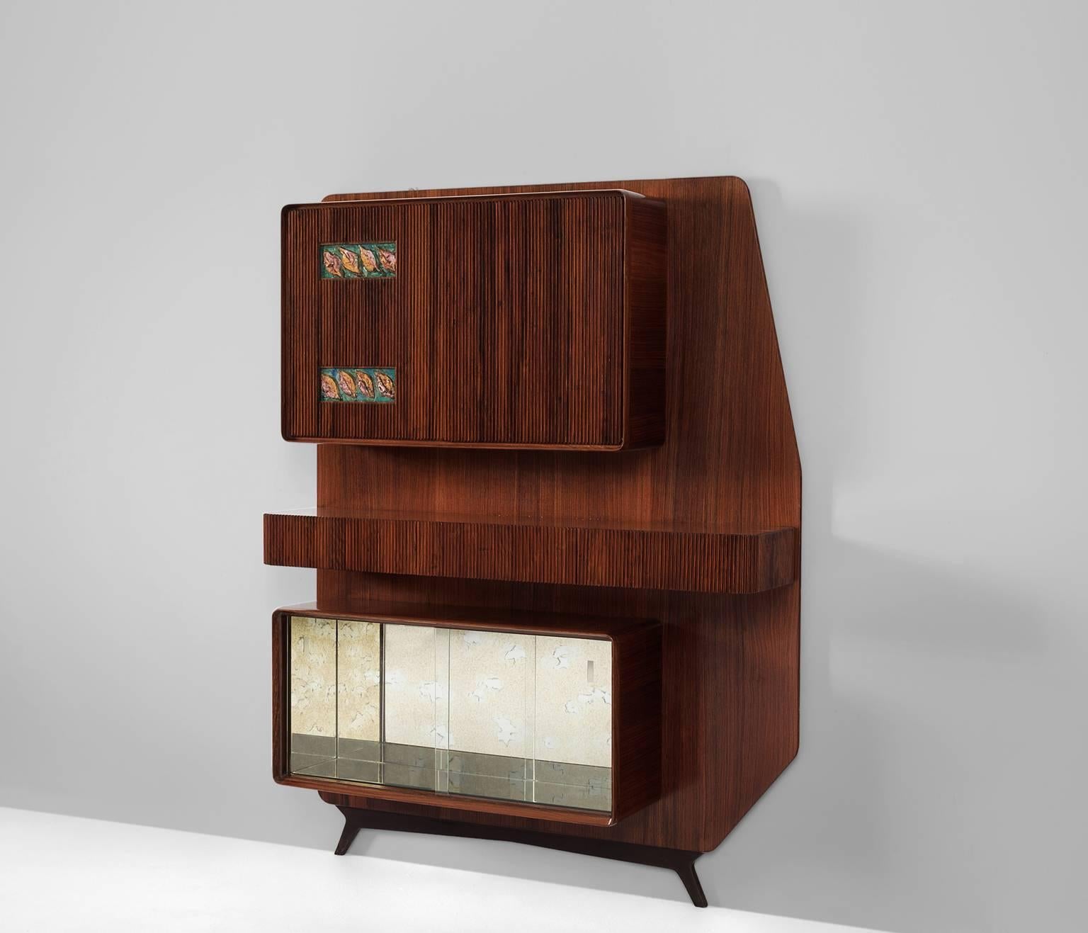 Wall Console in rosewood, glass and ceramic, Italy 1950s.

Eccentric wall console in rosewood. The console consists of cabinets and a shelf or bar. Nicely detailed with ridges rosewood, which emphasizes the verticality of the module.  

The