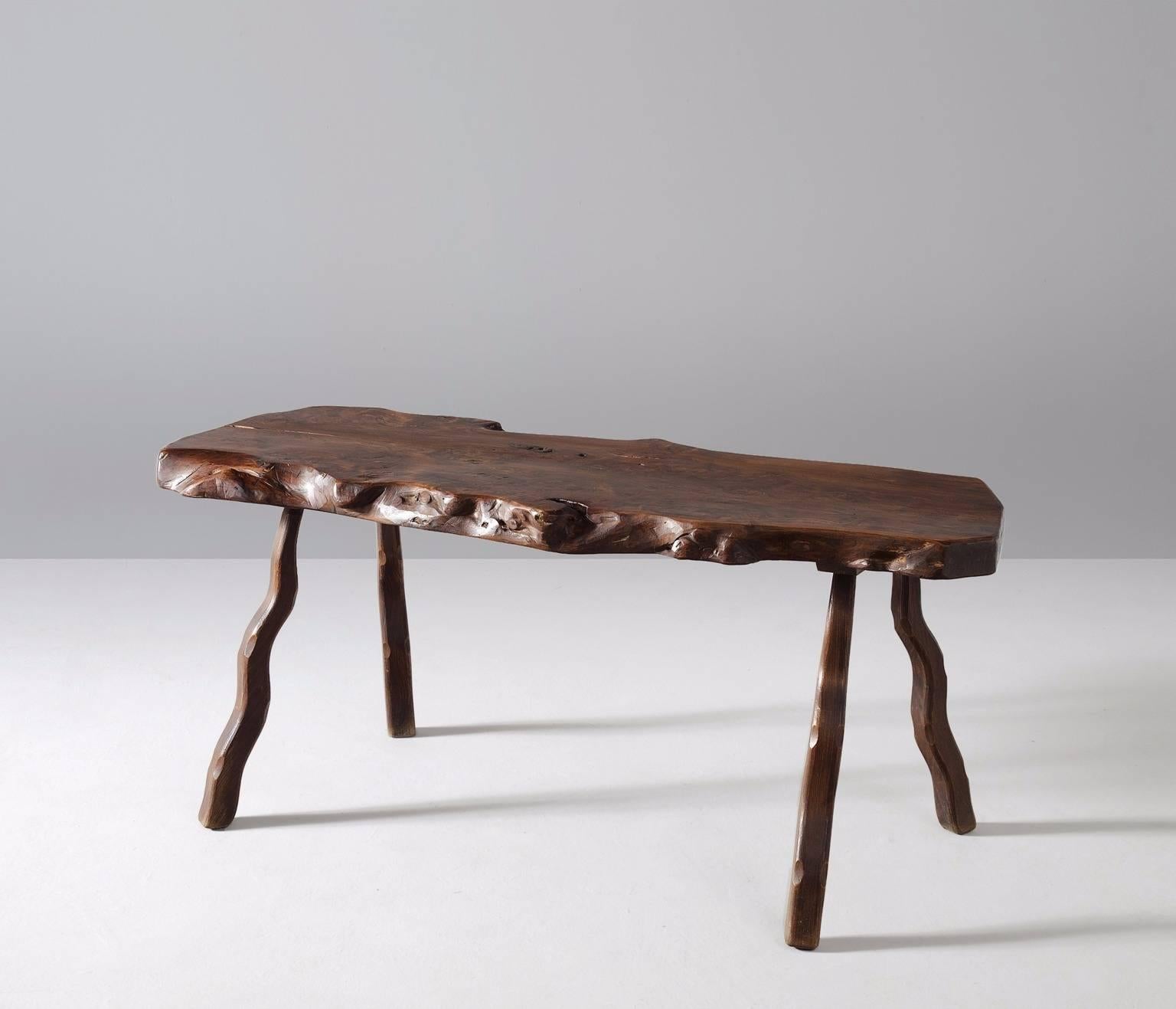 Dining table, elmwood, France, 1970s. 

Root dining table in elm, solid and dark brown stained. This four-legged table has a capricious appearance, due to the natural form and structure of the wood. Beautiful grain and expression which looks like