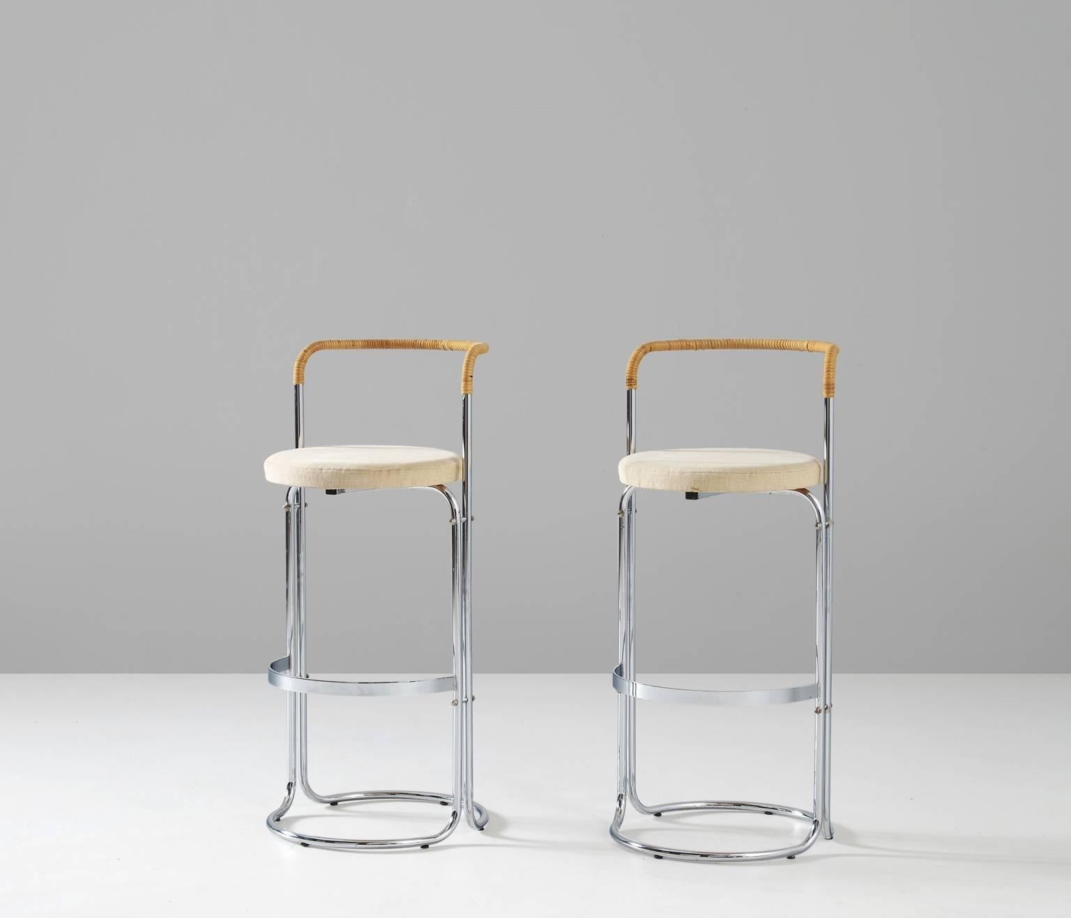 A pair of bar stools, in steel, rattan and fabric, designed by Poul Nørreklit for Georg Petersens, Denmark, 1970s. 

Bar stools with a chromed tubular steel frame. Round seating upholstered with beige fabric. De semi-circled back is wrapped in
