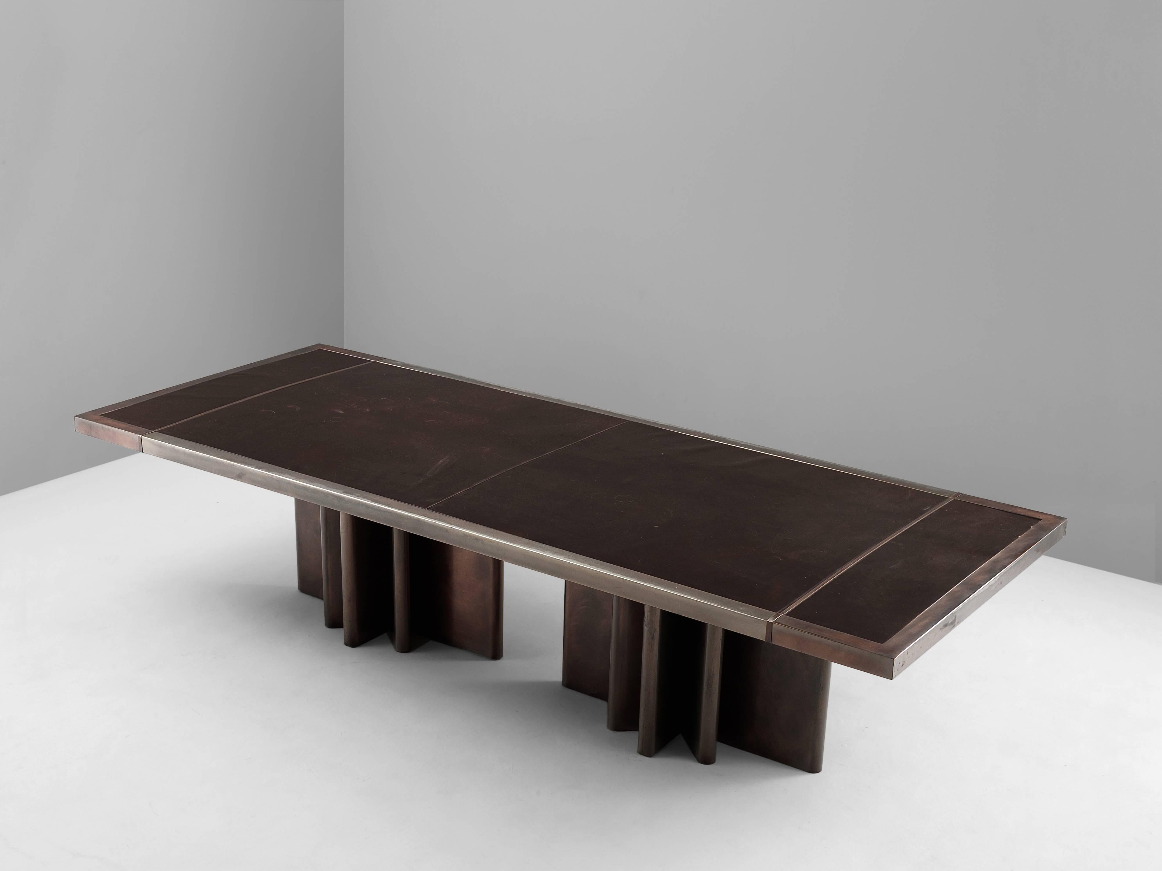 Conference table, in leather and metal, Belgium 1970s. 

Large conference table in metal wit dark brown leather top. Two metal legs in the shape of stars. The metal shows a nice copper colored patina which beautifully blends with the dark brown of