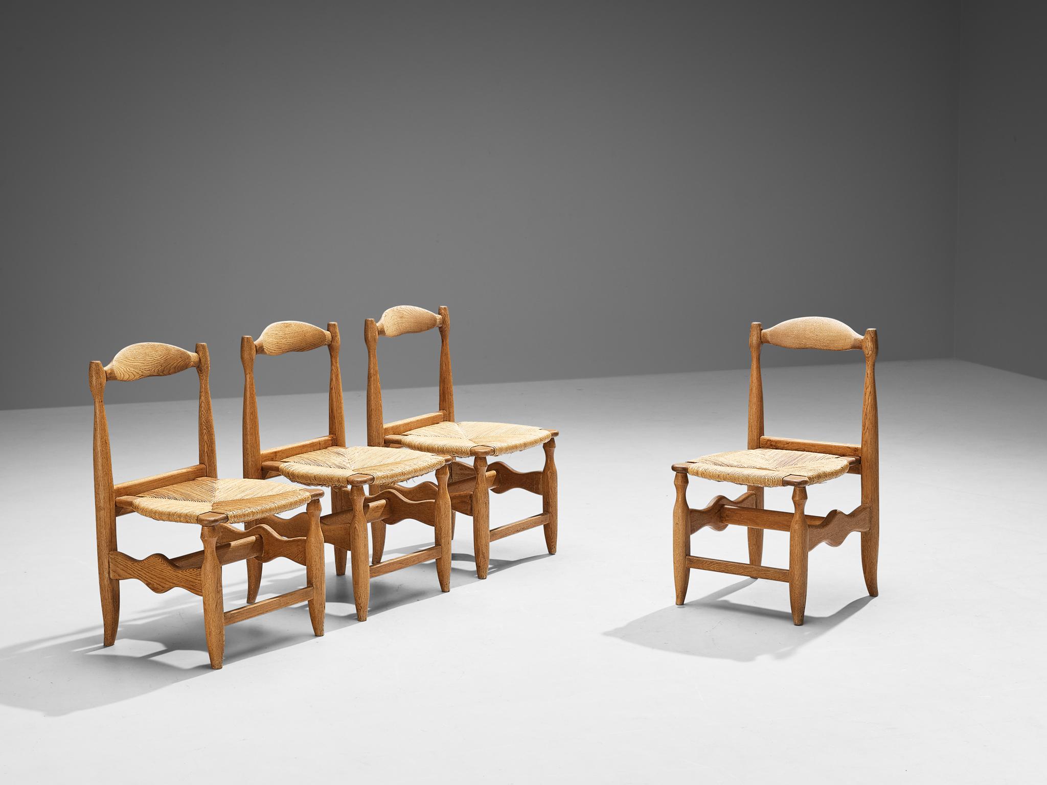 Guillerme et Chambron for Votre Maison, set of four dining chairs model 'Charlotte', solid oak, rush, France, 1960s

A set of four rustic yet elegant dining chairs crafted from solid oak and designed by Guillerme & Chambron. Signature design