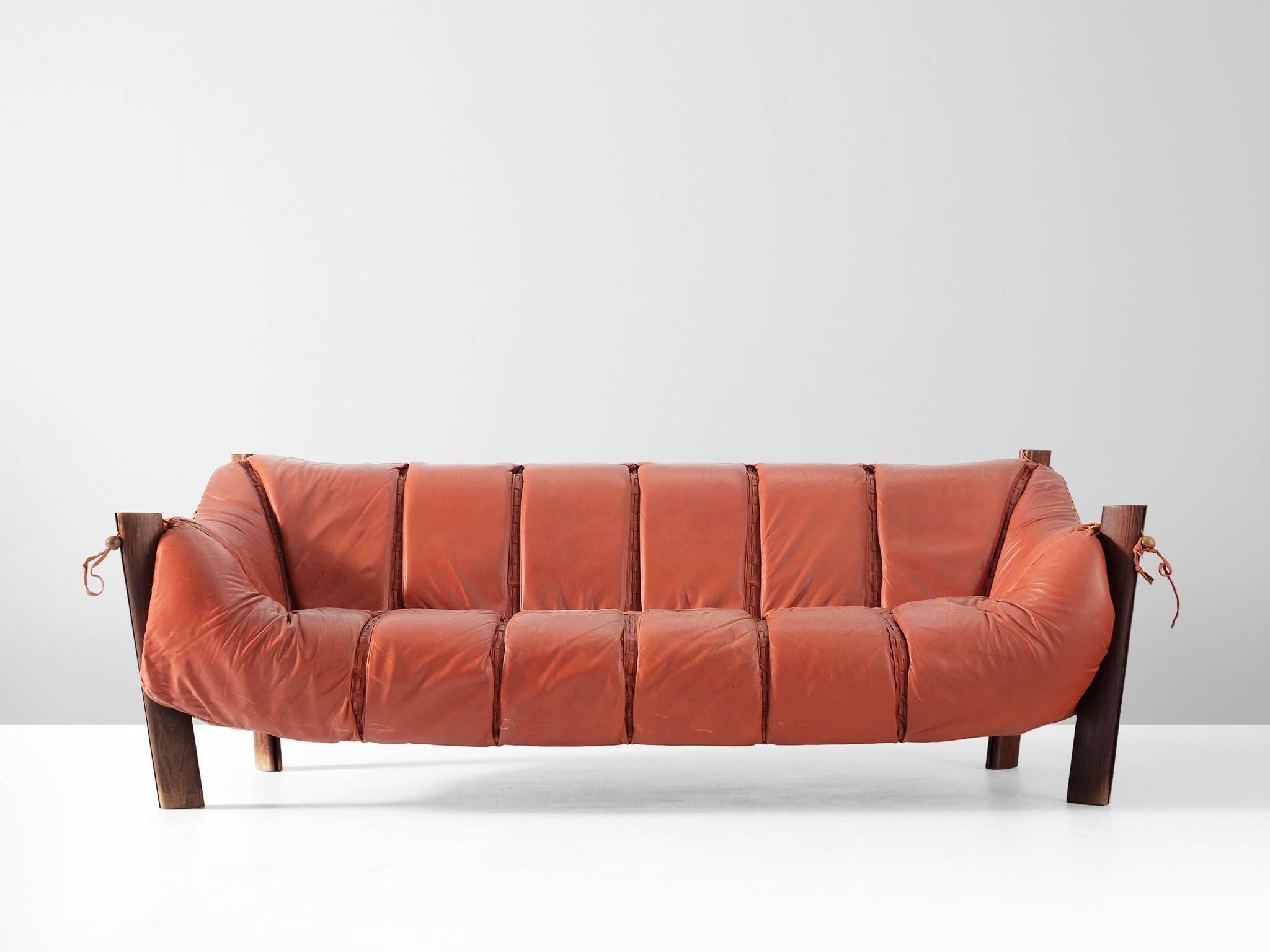 Sofa model MP-211, in jacaranda wood and leather, by Percival Lafer, Brazil 1974.

Three-seat sofa by Brazilian designer Percival Lafer. This sofa consist of a solid Jacaranda base in which the leather seating 'hangs'. Soft cushions are folded over