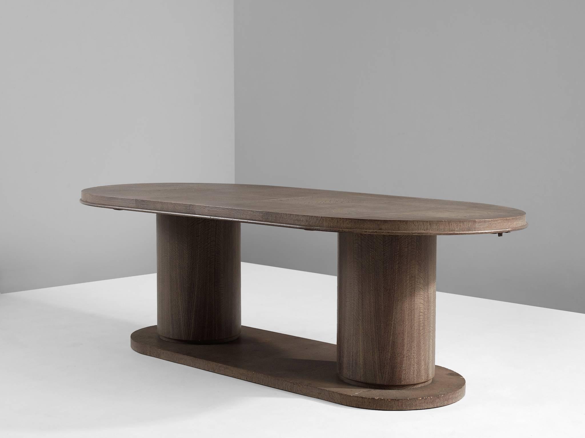 Dining table, in cerused oak, by De Coene, Belgium, 1930s. 

Imposing large oval center table. This table has a strong and sturdy appearance, due the two column base. While the design looks simplistic, the top is highly detailed. The oval shaped