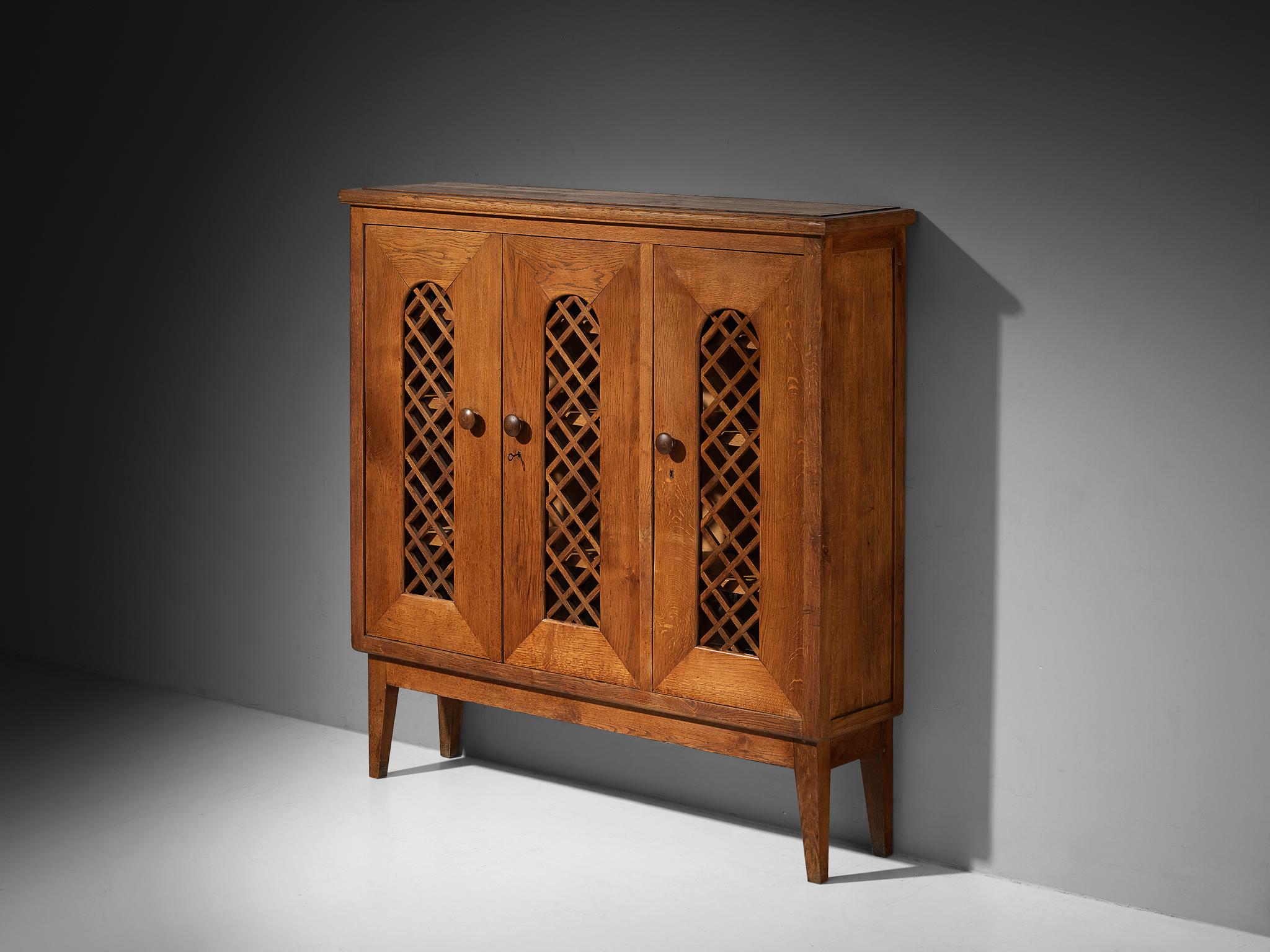 Cabinet, oak, glass, Italy, 1940s

A design that quietly bridges the gap between sleek modernism and handcrafted warmth. The cabinet’s facade is composed of three tall, narrow doors evenly spaced, each framed with an arched framework with