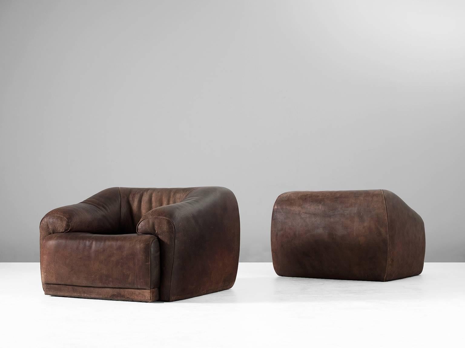 Set of lounge chairs, in leather,by De Sede Switzerland, 1970s.

Sturdy and highly comfortable lounge chairs in dark brown leather. These cubic chairs have a real masculine appearance. The back and armrest run smoothly over into each other and are