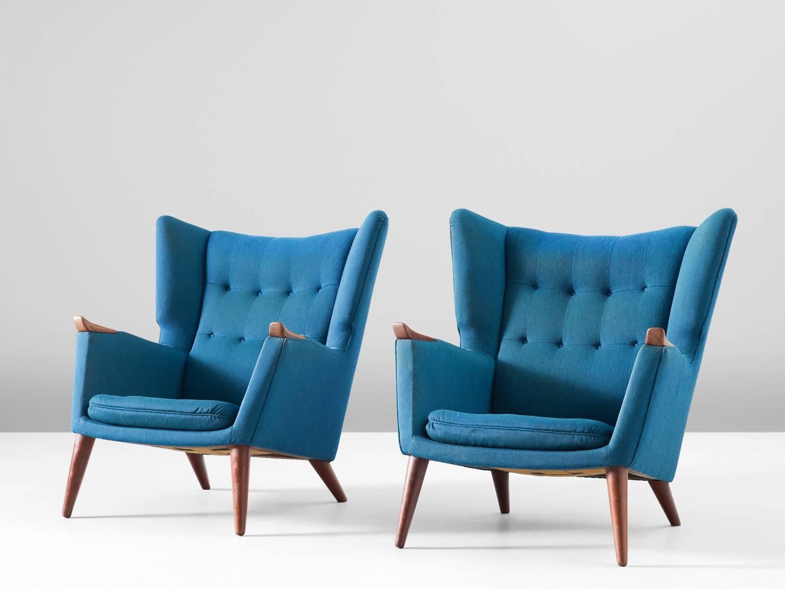Pair of lounge chairs, in teak and fabric, by Kurt Østervig, Denmark 1960s. 

Highly comfortable pair of lounge chairs with clear traits of the Danish modern style. This royal design by Ostervig has a more solid and closed character. The high back