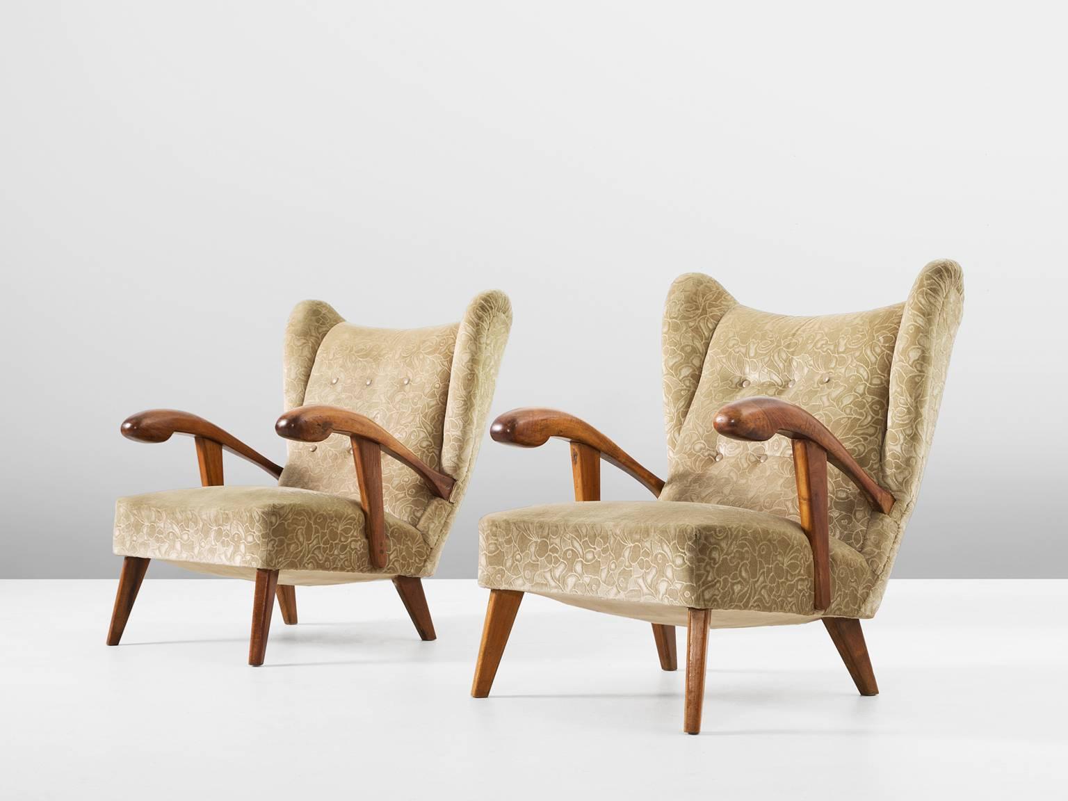 Set of two lounge chairs, in walnut and fabric, Czech Republic, 1950s. 

Elegant pair of two wingback chairs with solid walnut frame. These chairs show beautiful lines and curves. Upholstered in crème colored velvet with floral pattern. The grain