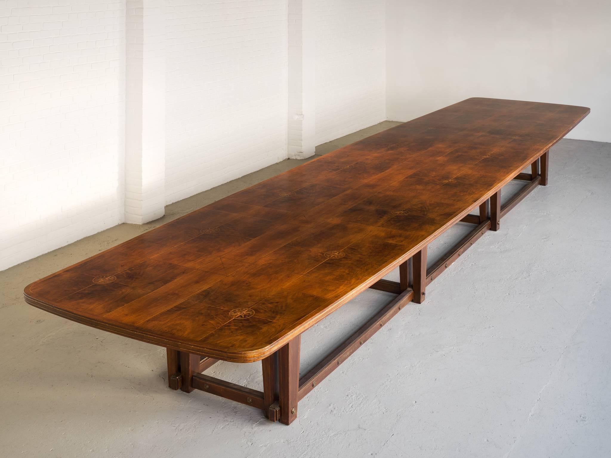 Conference table, in walnut, Europe, 1950s. 

Extremely large conference table in walnut. The top show beautiful inlayed wood. A geometric pattern is created due horizontal and vertical lines. Replenished with the illustration of compass-card. The