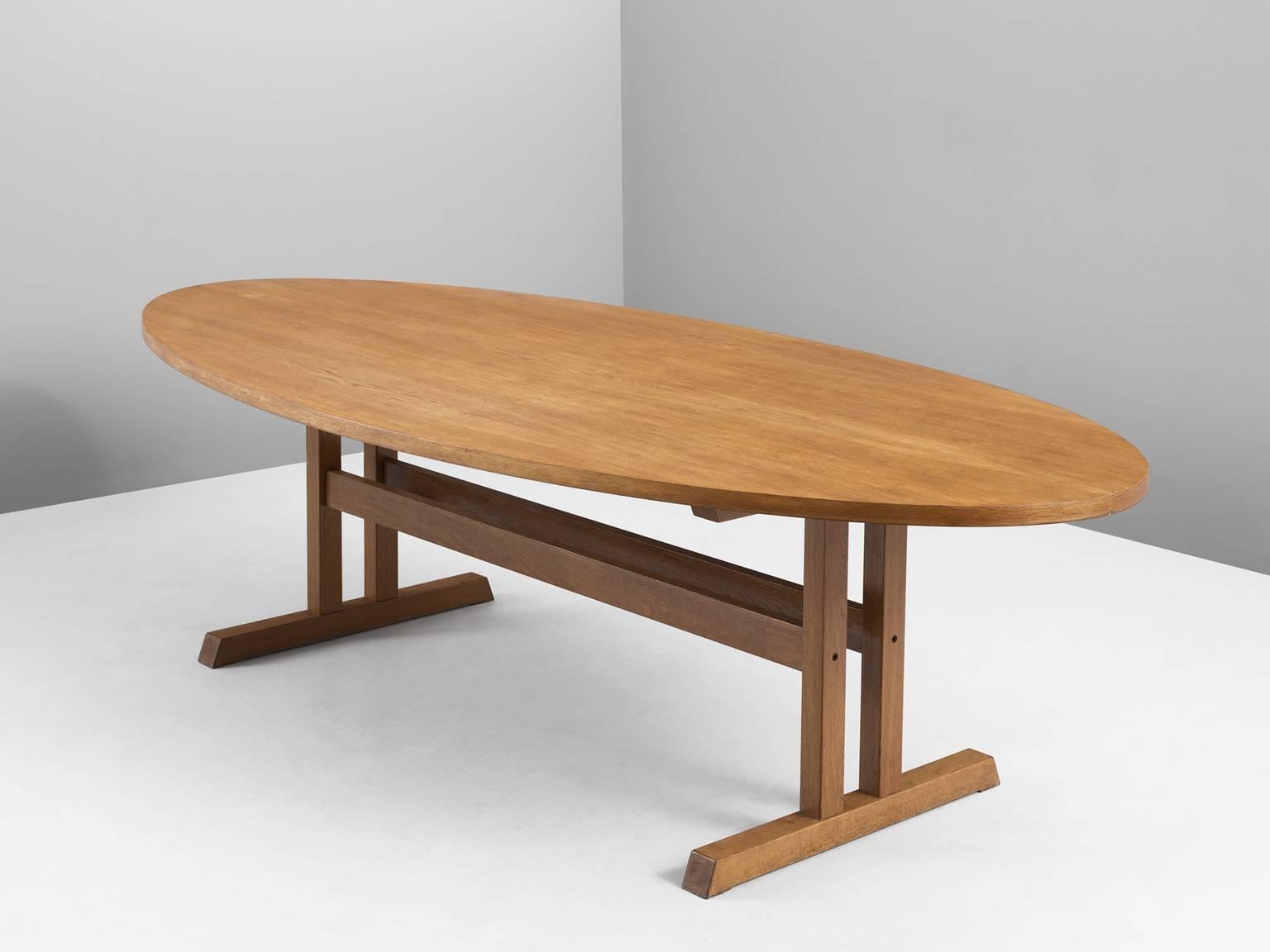 Dining table, in oak, Denmark 1960s. 

Oval dining table in blond oak. The table consist of a two leg base with cross-connections. The base is doubled with two sled feet. An oval shaped top shows the beautiful grain of the oak and emphasizes the