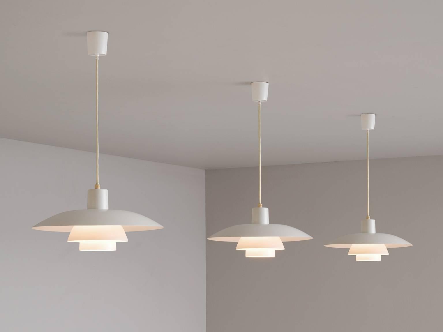 Set of three pendants model PH4/3, in metal, by Poul Henningsen for Louis Poulsen, Denmark, 1950s. 

Set of three iconic PH chandeliers designed by Poul Henningsen. Consisting of three curved shades of white coated metal. The spectator has no direct