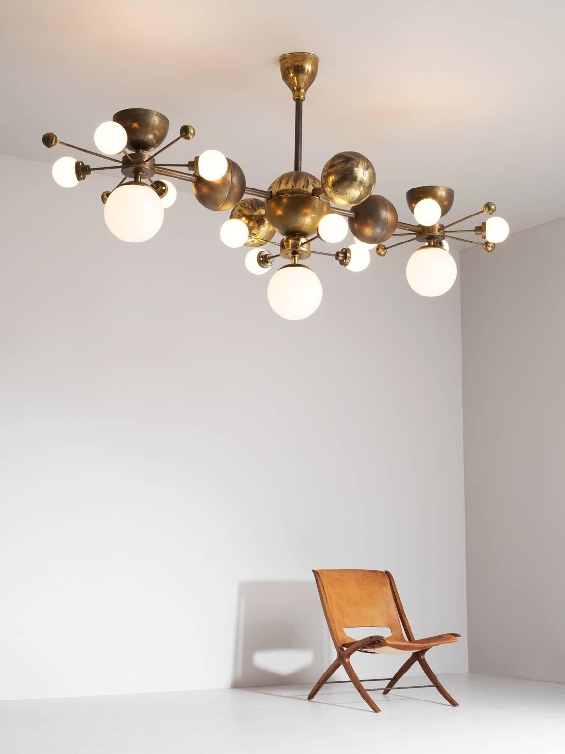 Chandelier, in glass and brass, Europe 1960s.

Extreme large chandelier with brass fixture and opaline glass spheres. Due the combination of materials and the several levels, this chandelier has a warm and diffuse light and a stunning
