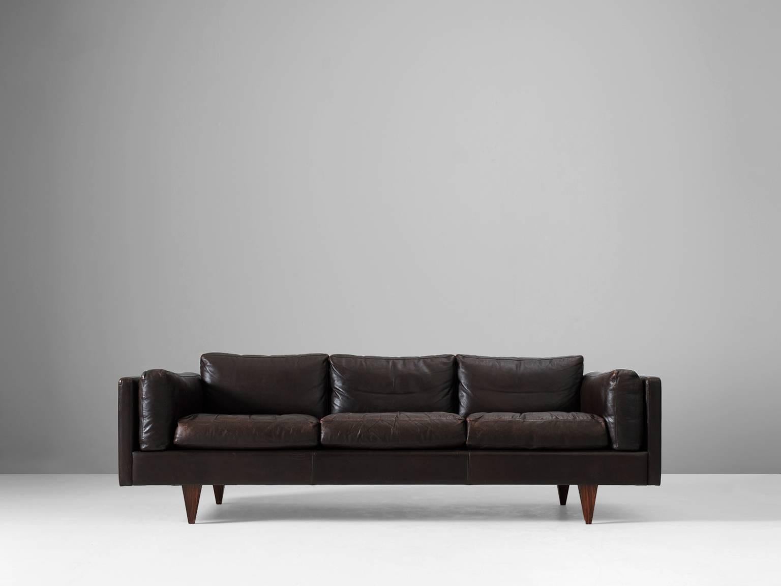 Three-seat sofa, brown leather and wood by Illum Wikkelsø, Denmark, 1960s.

This sofa is one of the best Mid-Century designs to be found in Denmark. It shows great craftsmanship and is in a wonderful condition. Due to the luxurious down filled