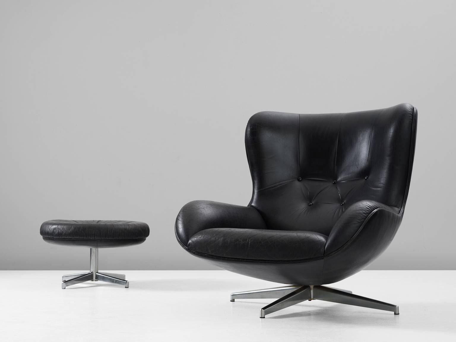 Swivel lounge chair model ML214, in leather and metal, by Illum Wikkelsø, Denmark, 1960s. 

Organic shaped easy chair and accompanying ottoman in black leather by Danish designer Illum Wikkelsø. Rare to find as a set in this excellent condition.