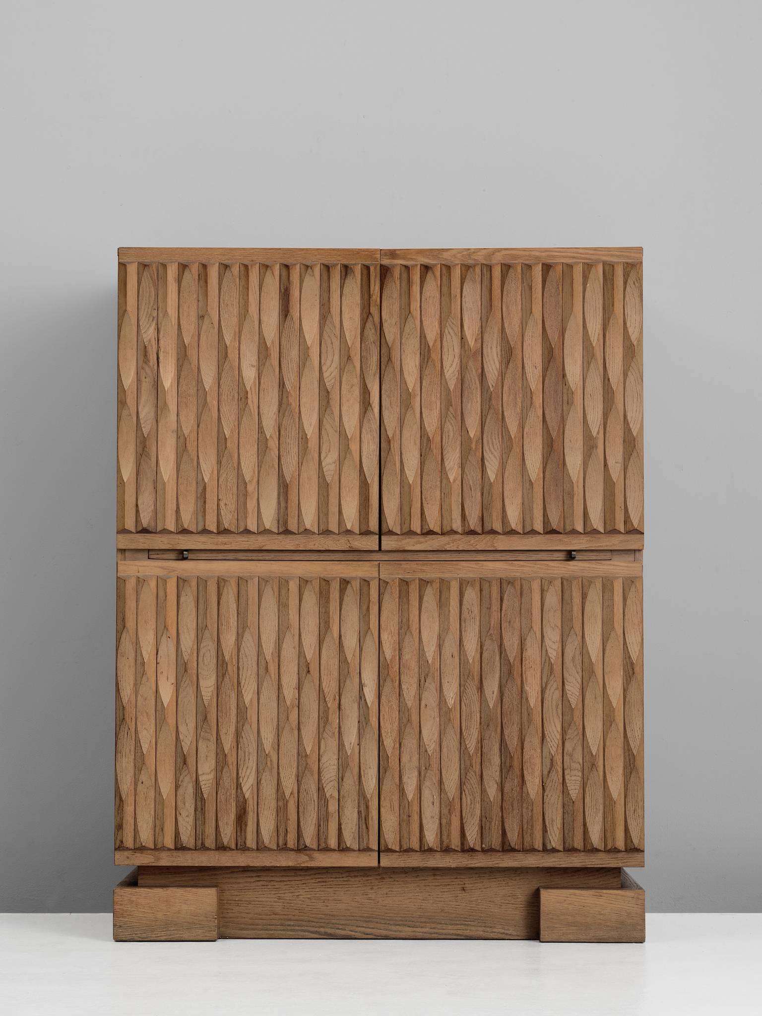 Sideboard, in oak, Europe, 1970s.

Sturdy high-board in oak with graphical designed door panels. Four door panels, each with a exceptional three-dimensional pattern. The continuous pattern gives this bar-cabinet a very strong expression,