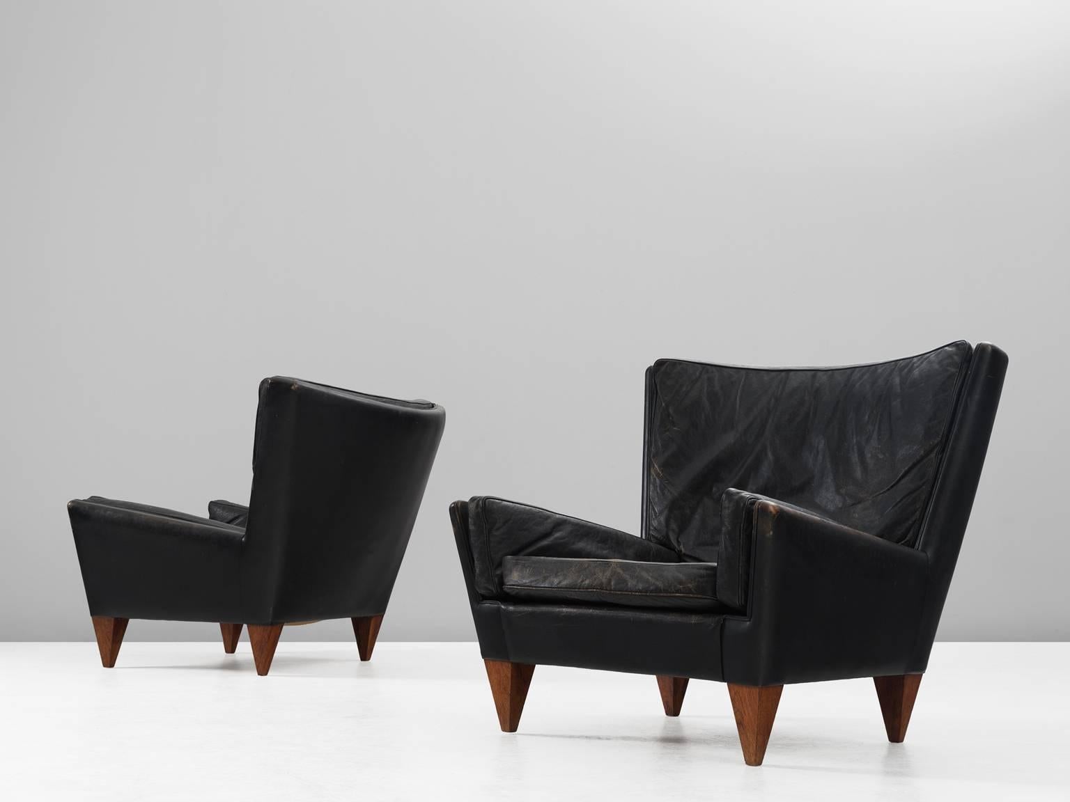 Two easy chairs model V11 'Pyramid,' in rosewood and leather, by Illum Wikkelsø for Holger Christiansen, Denmark, 1960s. 

Set of two lounge chairs in patinated black leather. This lounge chair was named after the pyramid shaped legs. The rosewood