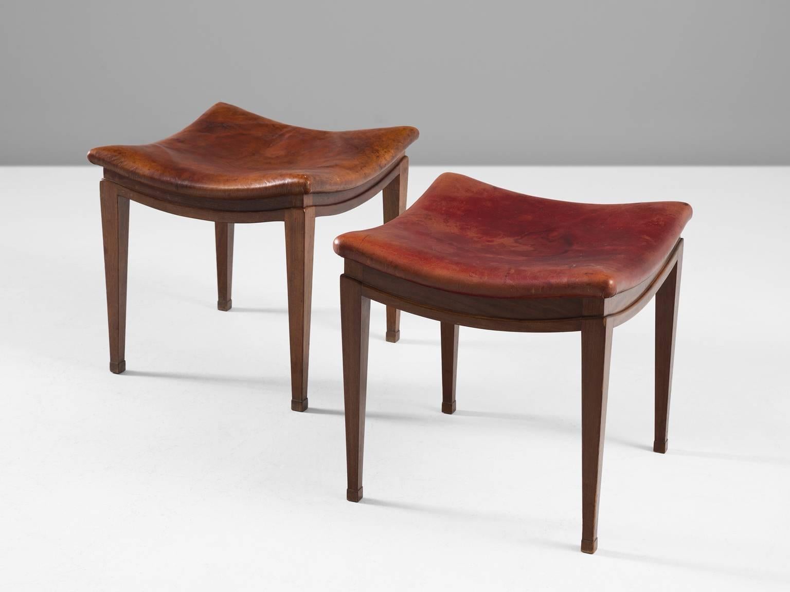 Set of two stools, in mahogany and leather, by Frits Henningsen, Denmark, 1940s.

A pair of stools in mahogany, upholstered in red and cognac leather. The great craftsmanship of Frits Henningsen is directly visible on these stools. Beautiful