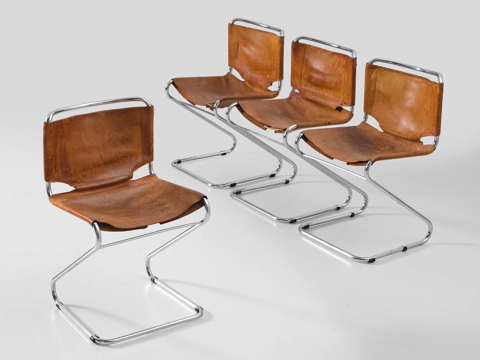 Set of four dining chairs, in steel and leather, Europe, 1960s. 

Set of four tubular dining chairs with cognac leather upholstery. These chairs have a very dynamic appearance due their frame of tubular chromed steel. The frame is S-shaped and