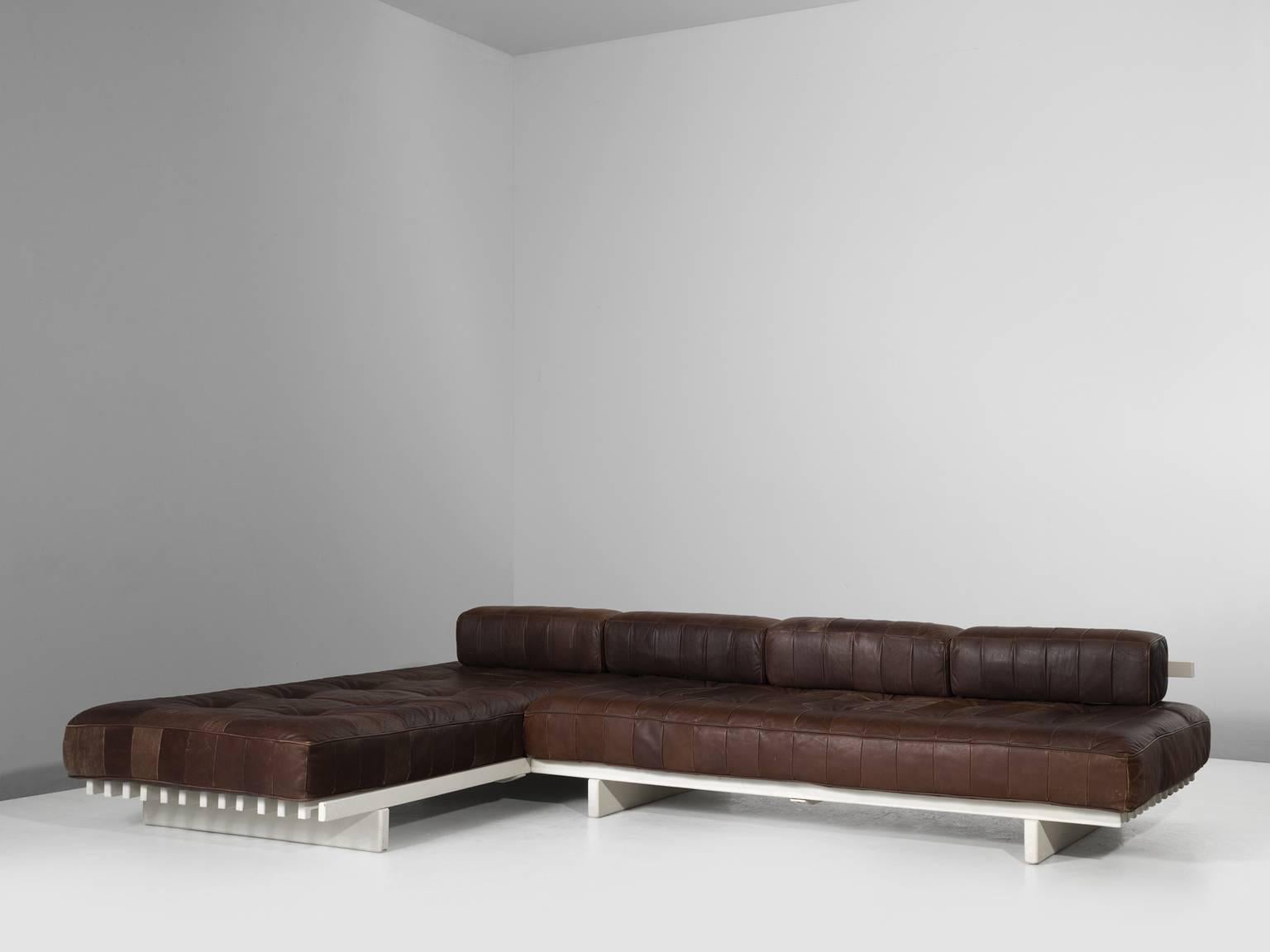 DS80 sofa, in leather and wood, by De Sede, Switzerland 1970s.

Sectional sofa by the Swiss quality manufacturer Desede. This sofa consists of two combined daybeds. The frame consists of white lacquered wooden slats. The cushions are upholstered