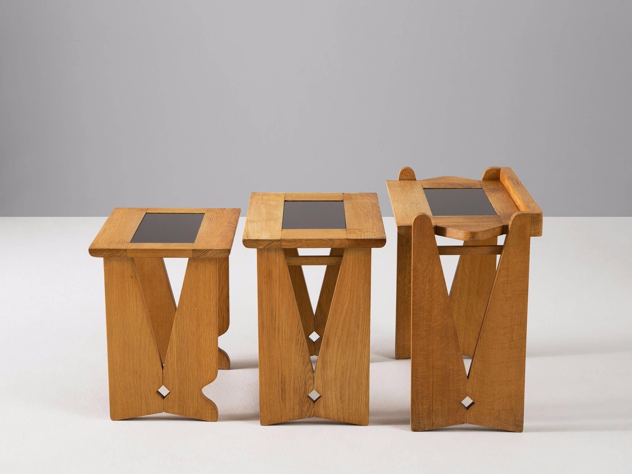 Set of three nesting tables, in oak and glass, by Robert Guillerme et Jacques Chambron for Votre Maison, France, 1960s.
 
Set of three side tables in oak and glass by French designer duo Guillerme and Chambron. A simplistic design with open