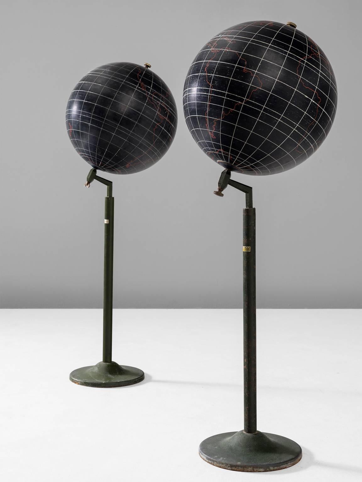 Globes, plaster and metal, 1970s, Europe.

These two black to anthracite standing globes are lovely as a pair. The coloring on the globes is done in red and the lines are white. The detailing is not very precise but instead gives an abstract IDEA