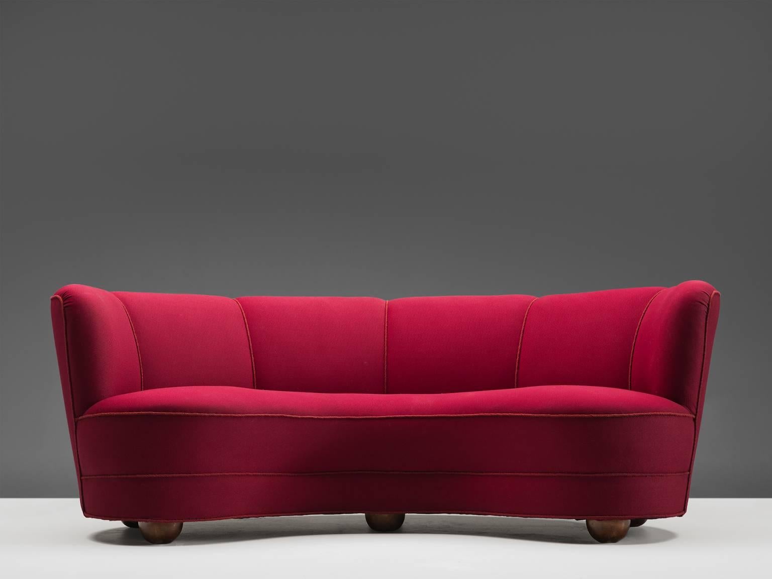Sofa, fabric, foam, brass, Italy, 1940s.

This sculptural, curvaceous sofa is a small but strong piece. The combination of the red color and lining is playful and stately at the same time. Six linings divide the back into six elements. The