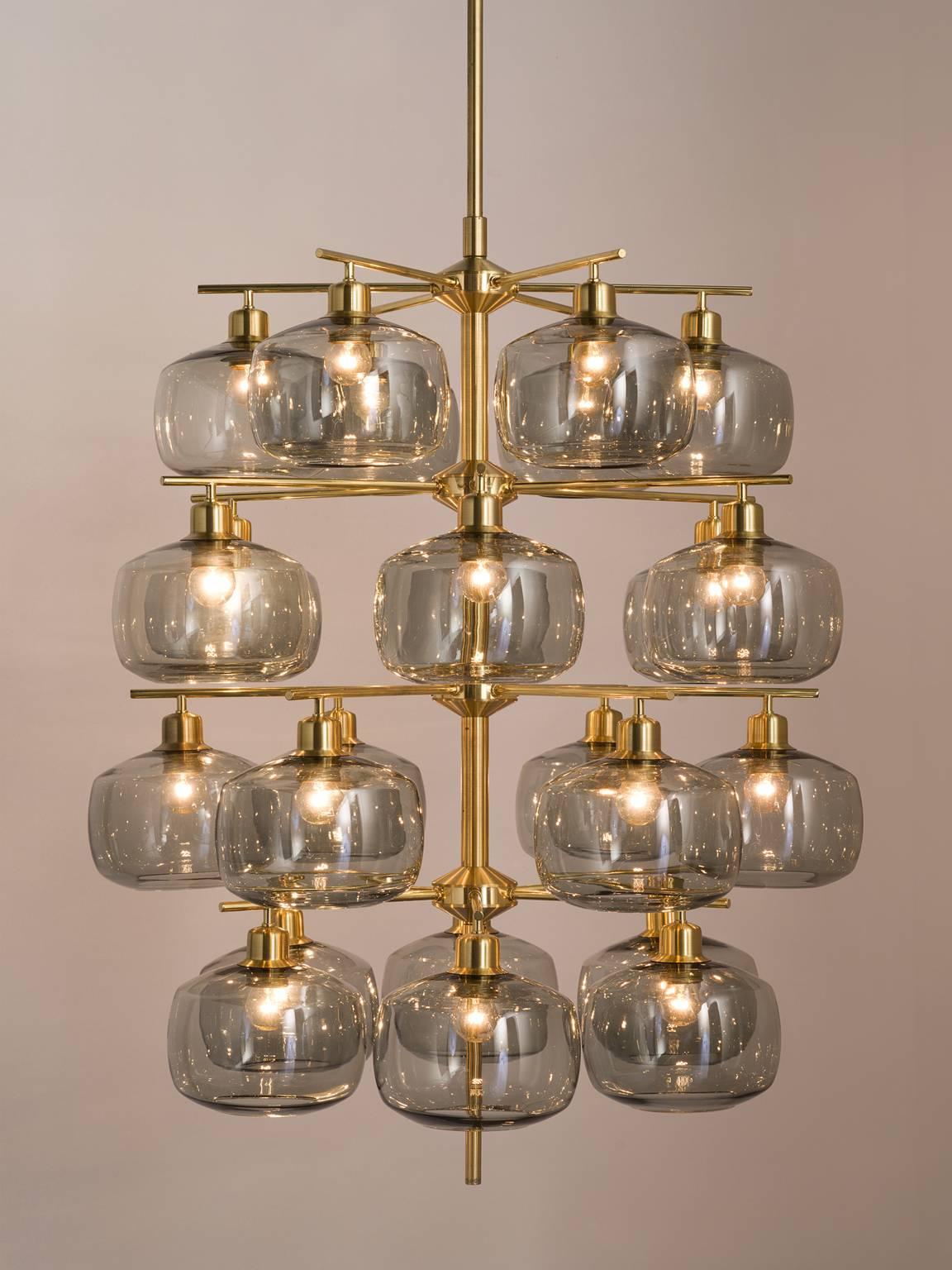 Set of eight chandeliers in brass and glass, 1952.

This large set of exceptional chandeliers feature a brass frame and translucent bulbs that resemble 'pressed' spheres. These Midcentury pendants are original thanks to the shape, quantity and