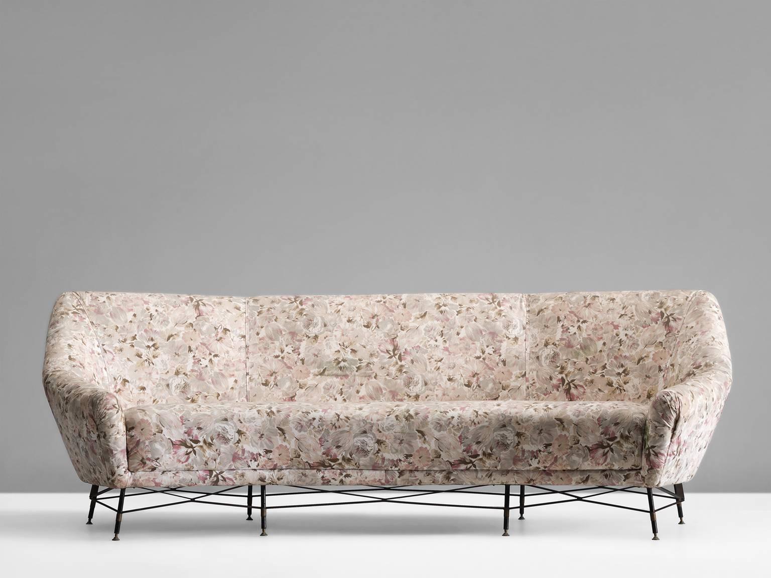 Sofa, in metal, brass and fabric, Italy, 1950s.

Large curved sofa with beautiful metal wire frame. This sofa has an elegant base of black coated metal with brass elements. The lines of the base show an interesting graphical pattern. The seating is