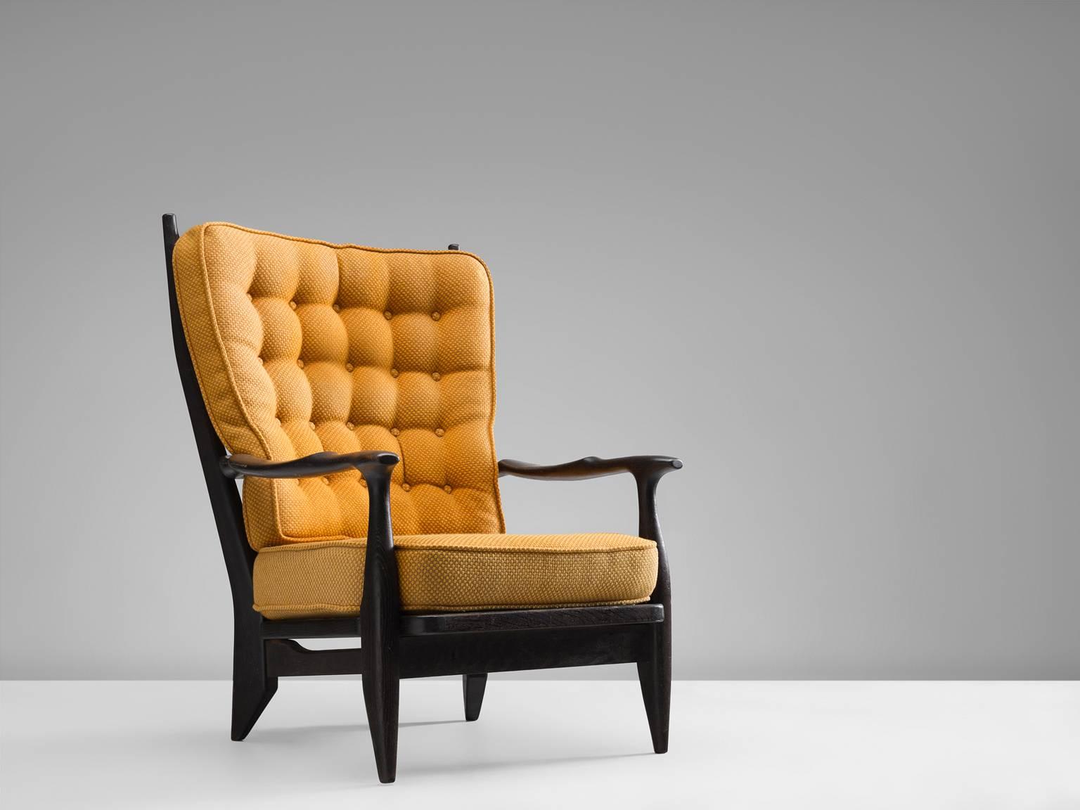 Lounge chair in black stained oak, with a curry colored upholstery by Guillerme et Chambron, France, 1960s. 

Guillerme and Chambron are known for their high quality solid oak furniture, from which this is another great example. This chair has a