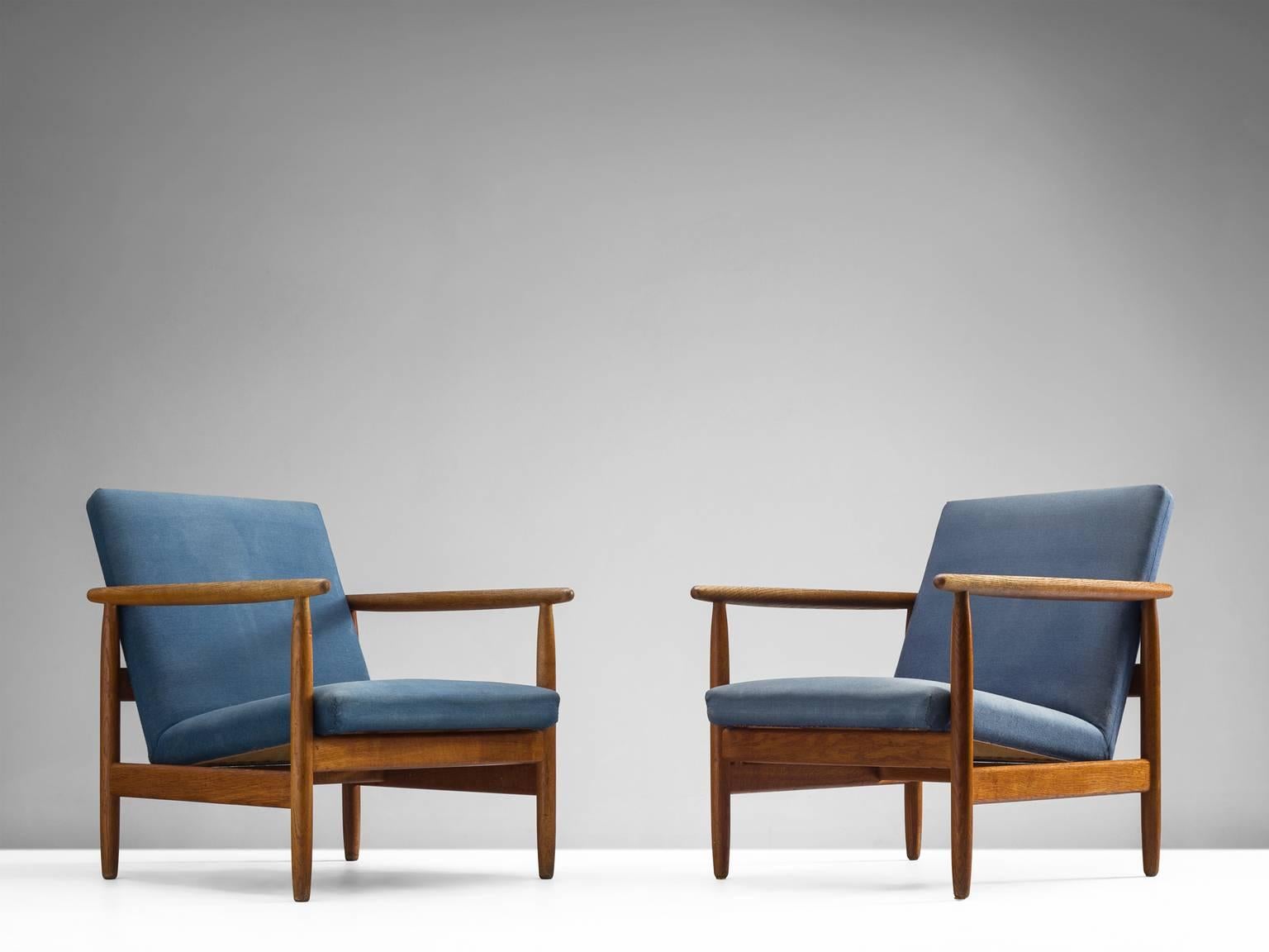 Pair of teak armchairs in original blue fabric, Denmark, 1960s.

The basic design of the frame is well executed. The solid teak has a warm expression and gives the chairs a friendly appearance. The chairs are well proportioned and provide great