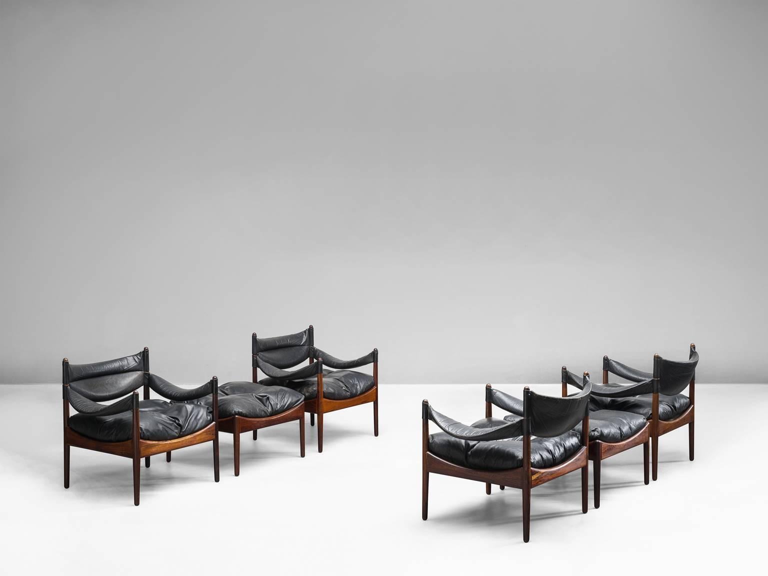 Large set of lounge chairs by Kristian Solmer Vedel, in rosewood and black leather. Design 'Modus', manufactured by Søren Willadsen, Denmark, 1960s.

This highly comfortable set of four armchairs is provided with two matching footstools. The