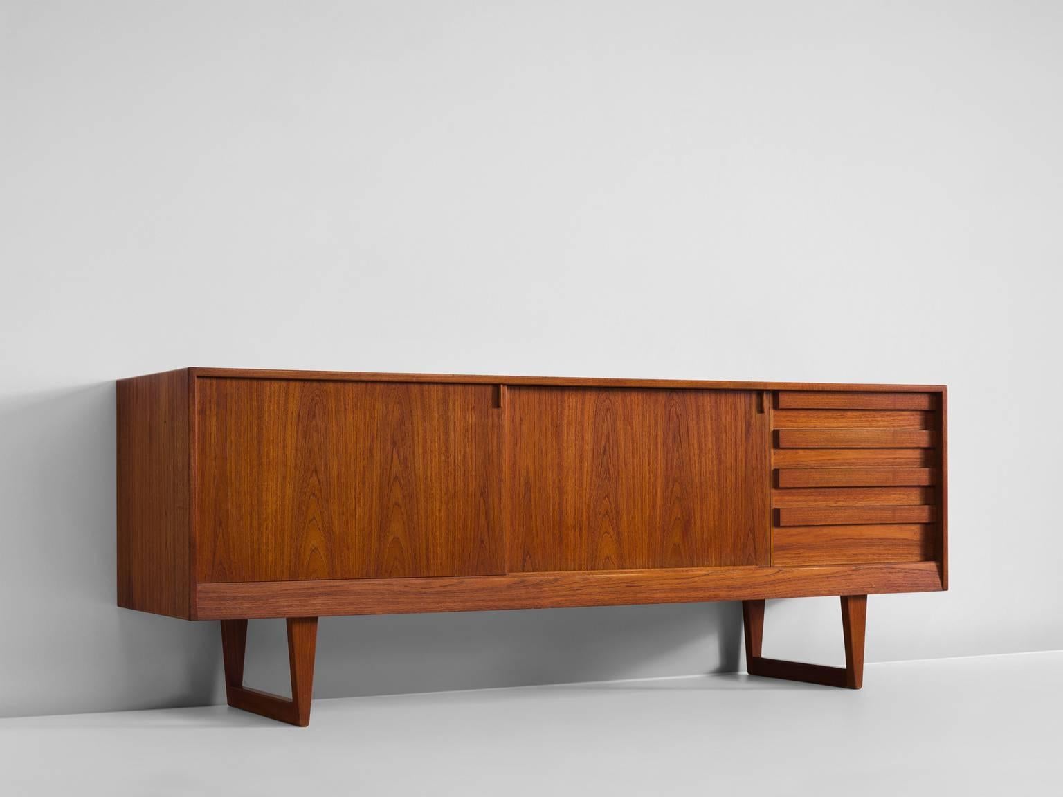 Sideboard with sled base designed by Kurt Østervig, teak, Denmark, 1960s/

This credenza features two sliding doors and four drawers. The sideboard shows some highly crafted details such as the handles on top of the drawers. 
Finished with a hardwax