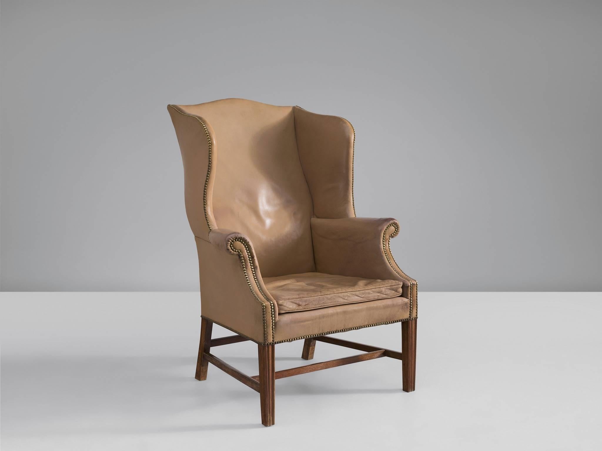 Wing back chair in mahogany and pale cognac leather, by Peter Hvidt & Orla Mølgaard Nielsen. Manufactured by Georg Kofoeds Møbelfabrik, Denmark, 1940s.

This ornate, royal armchair is executed in its original light cognac leather upholstery. The