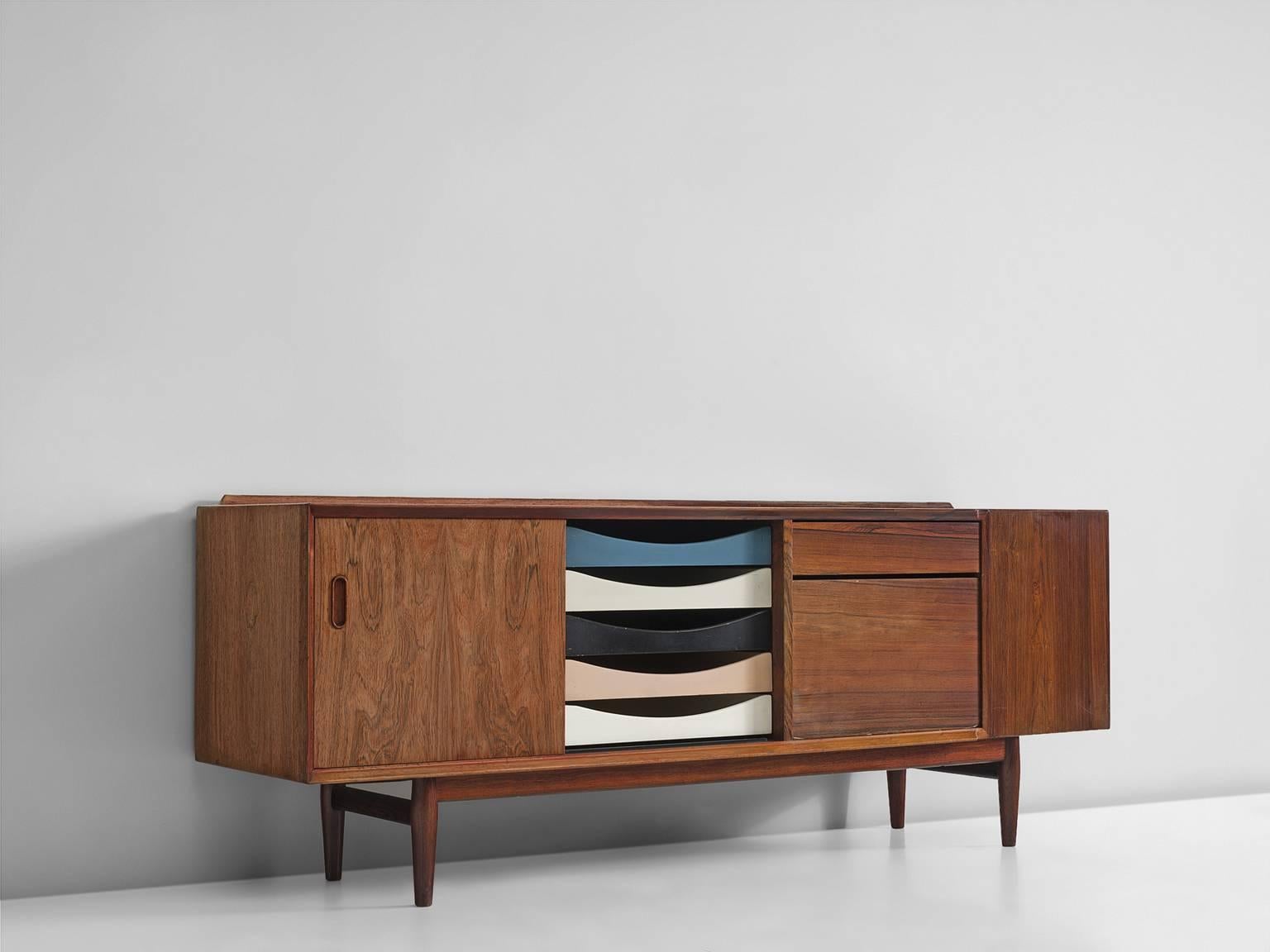 Sideboard, in rosewood, by Arne Vodder, Denmark, 1960s.

Small credenza in rosewood. Well designed sideboard with a sliding door and six concave shaped drawers. At the back of the top, a solid rosewood raised edge is made which gives the console a